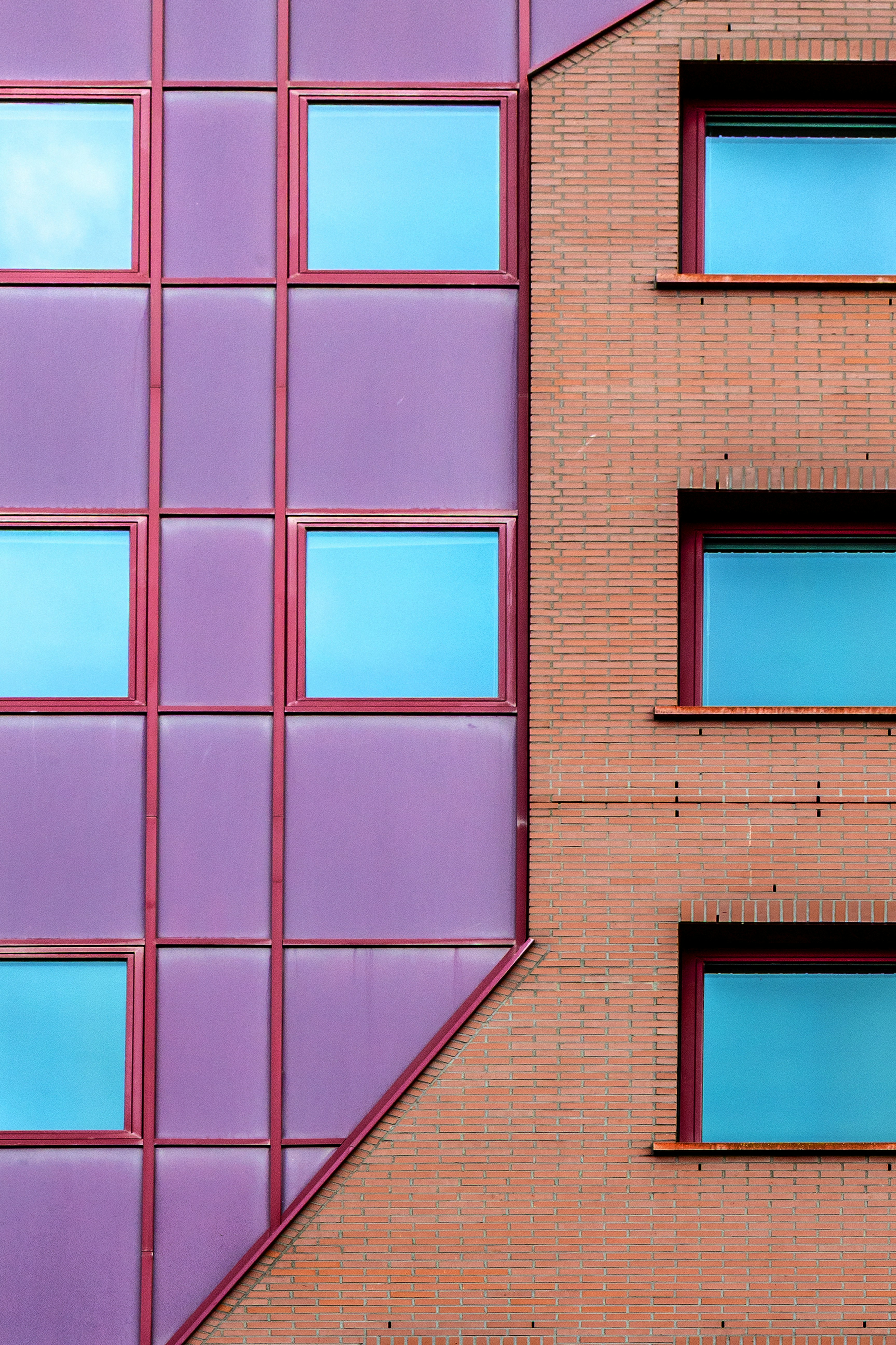 Modern building facade with purple and brick sections.