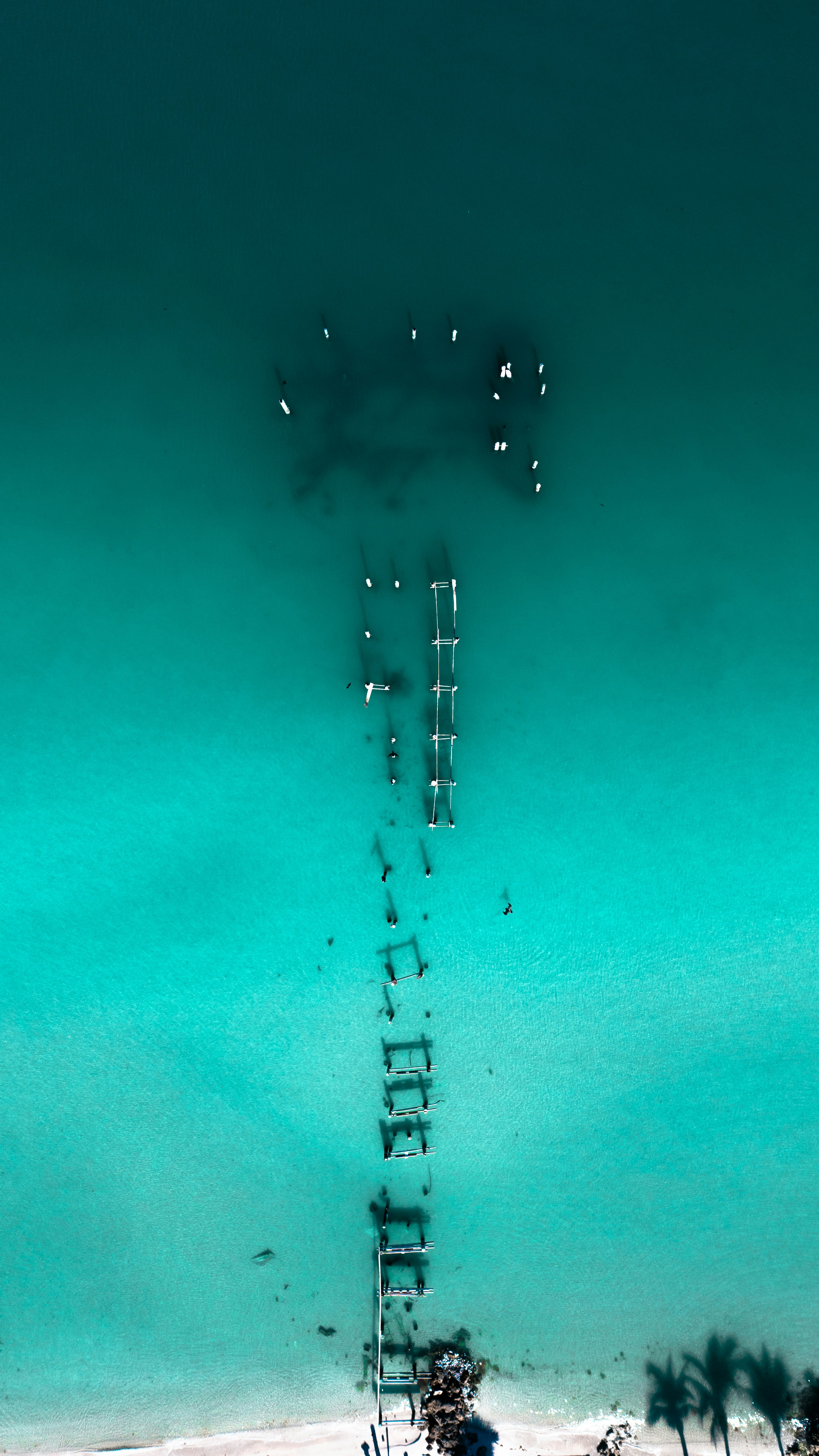 Vista aerea di un molo in decomposizione in acqua turchese dell'oceano