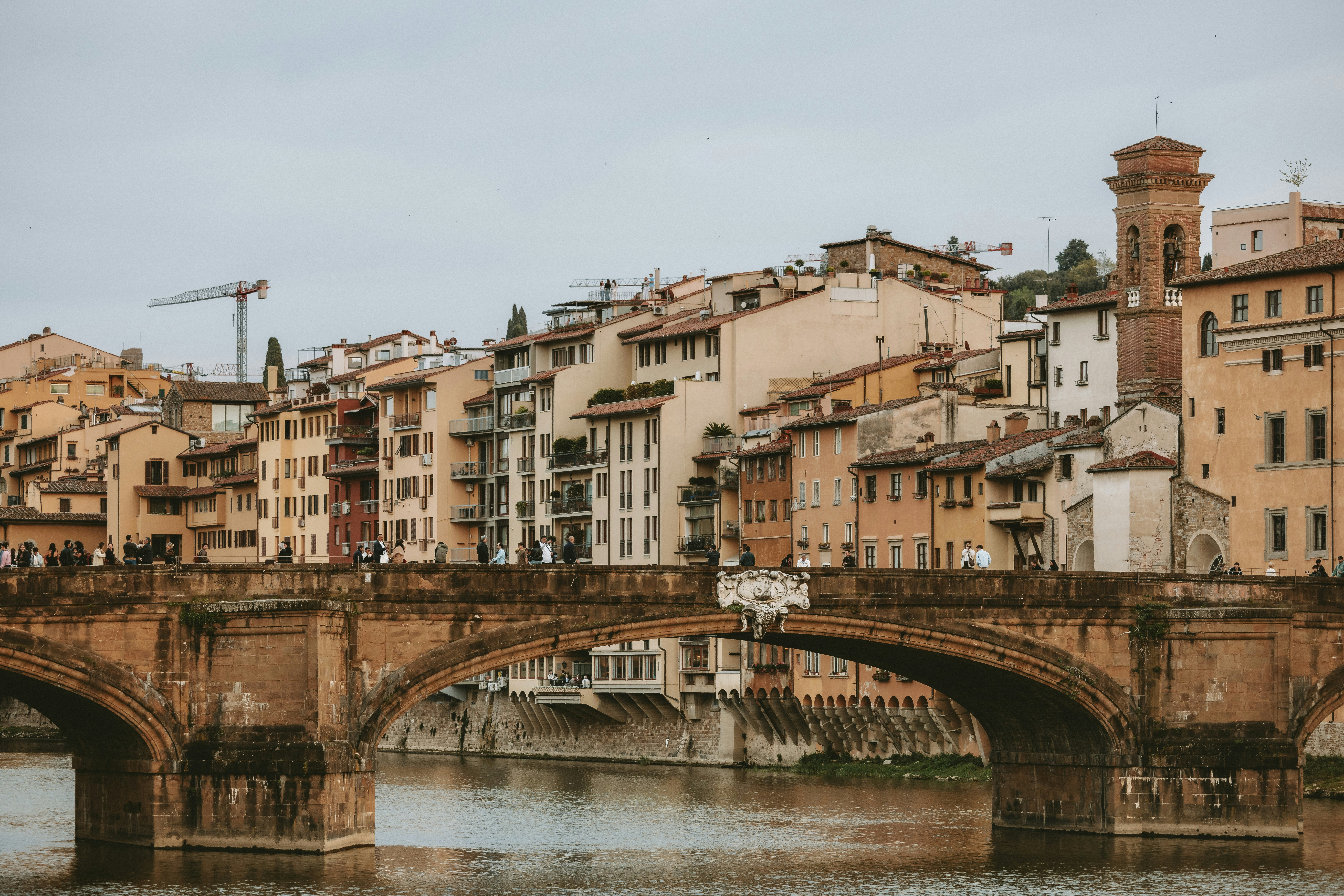 Vieux pont en pierre avec des bâtiments historiques en arrière-plan.
