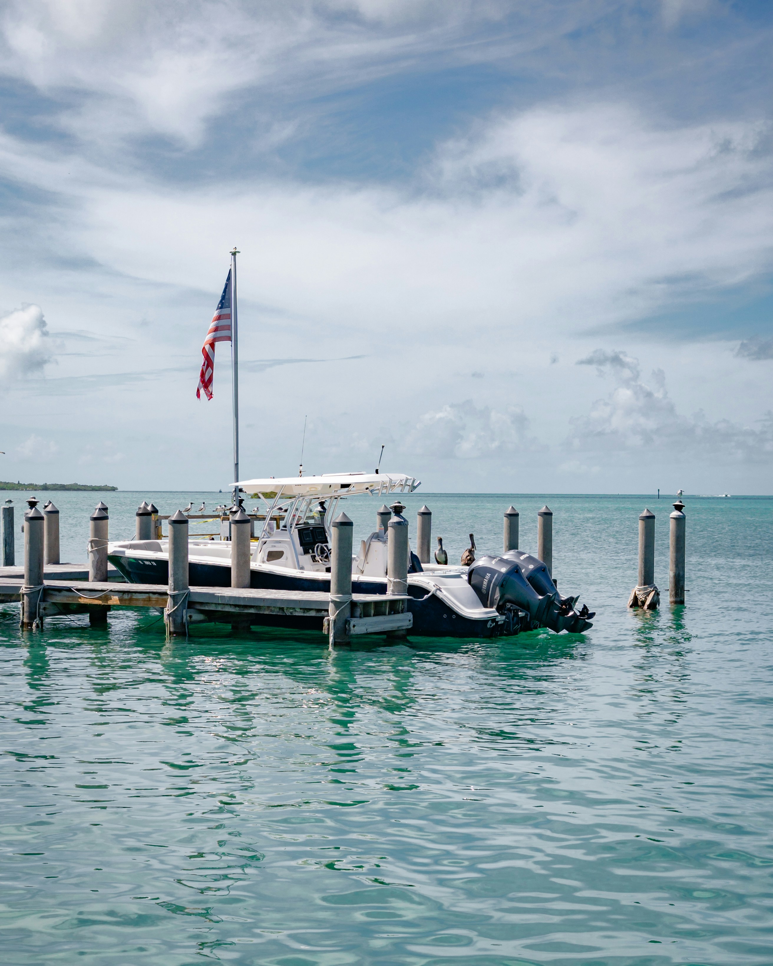 Boats docked on a pier under a cloudy sky