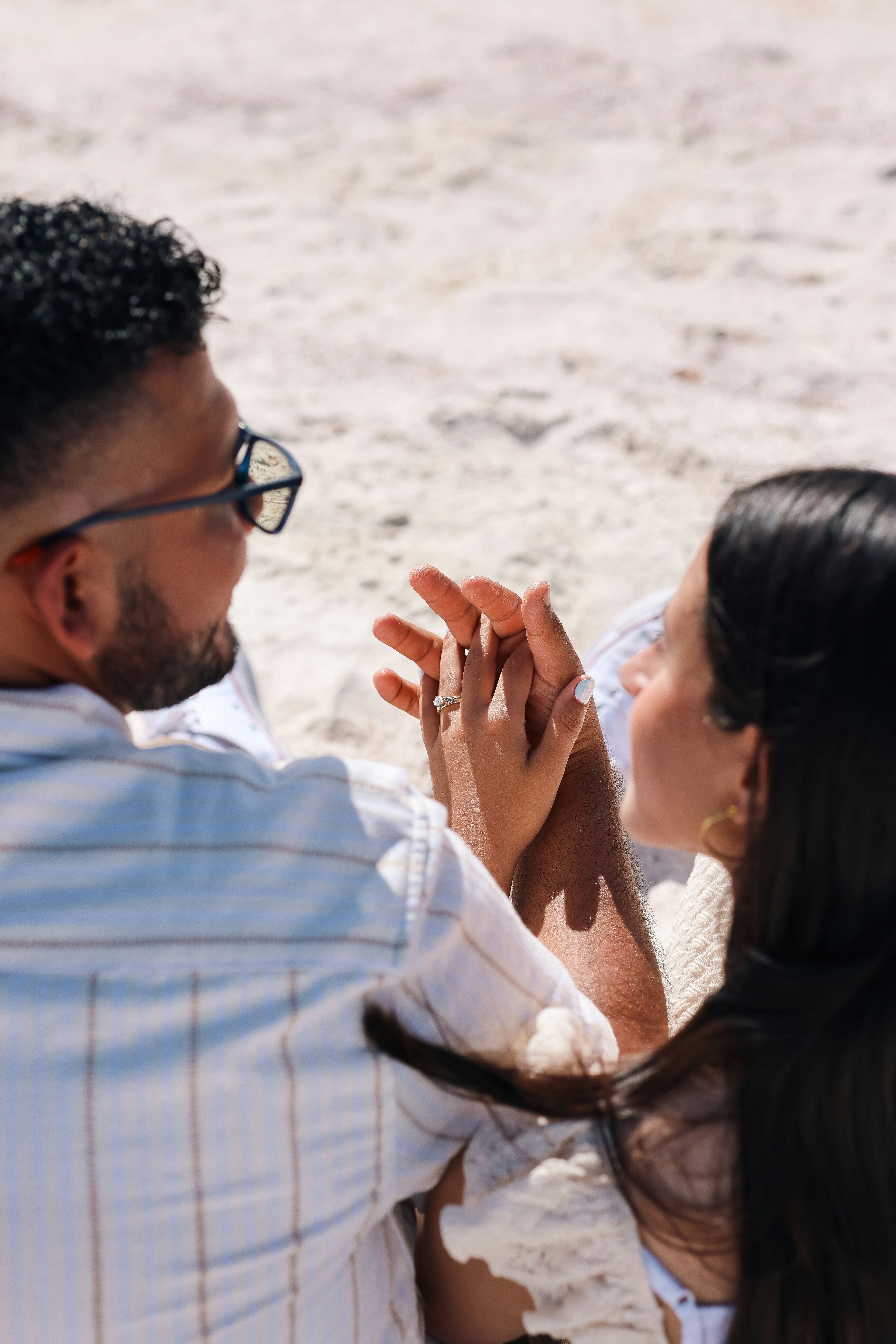Couple holding hands on a sandy beach