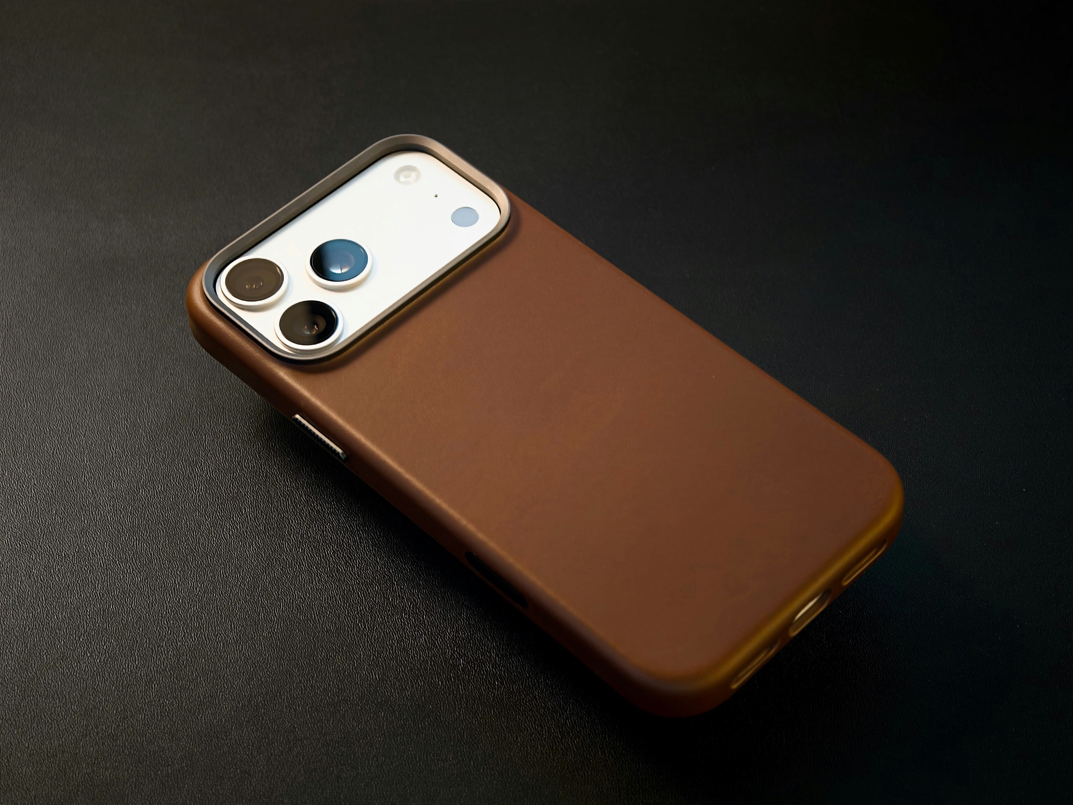 Brown smartphone case with camera lenses on dark background