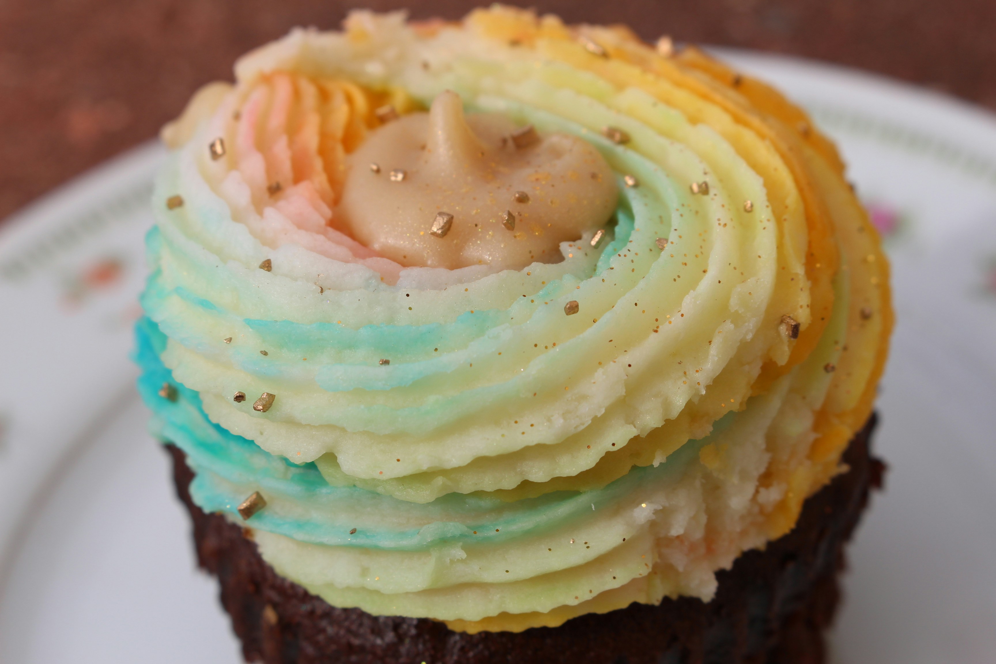 Cupcakes with rainbow frosting and gold sprinkles