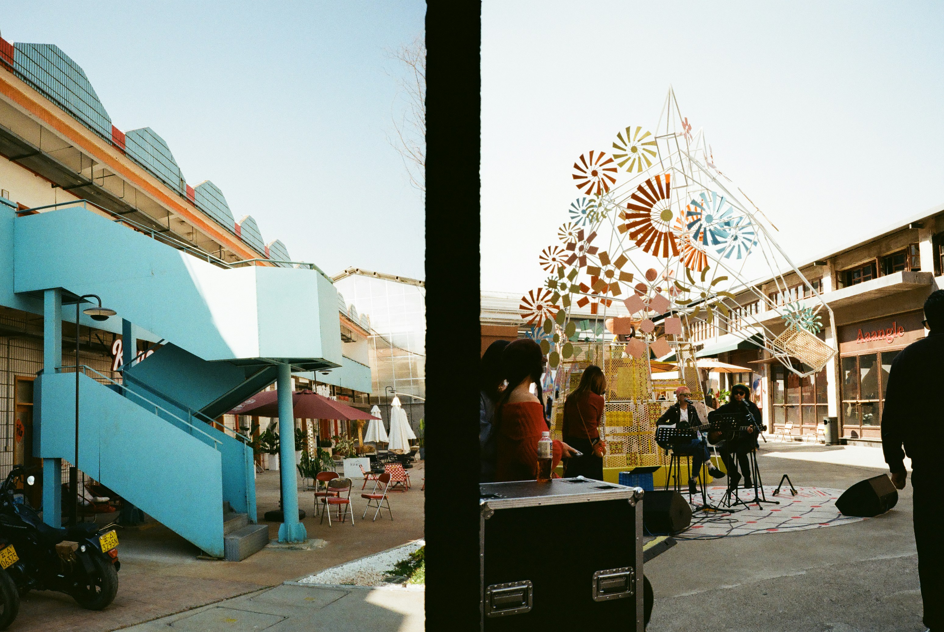 Outdoor market with blue stairs and a band playing