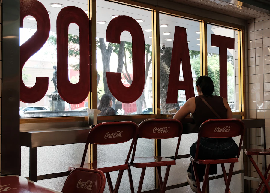 A person sitting at the counter of a taqueria waiting for an order