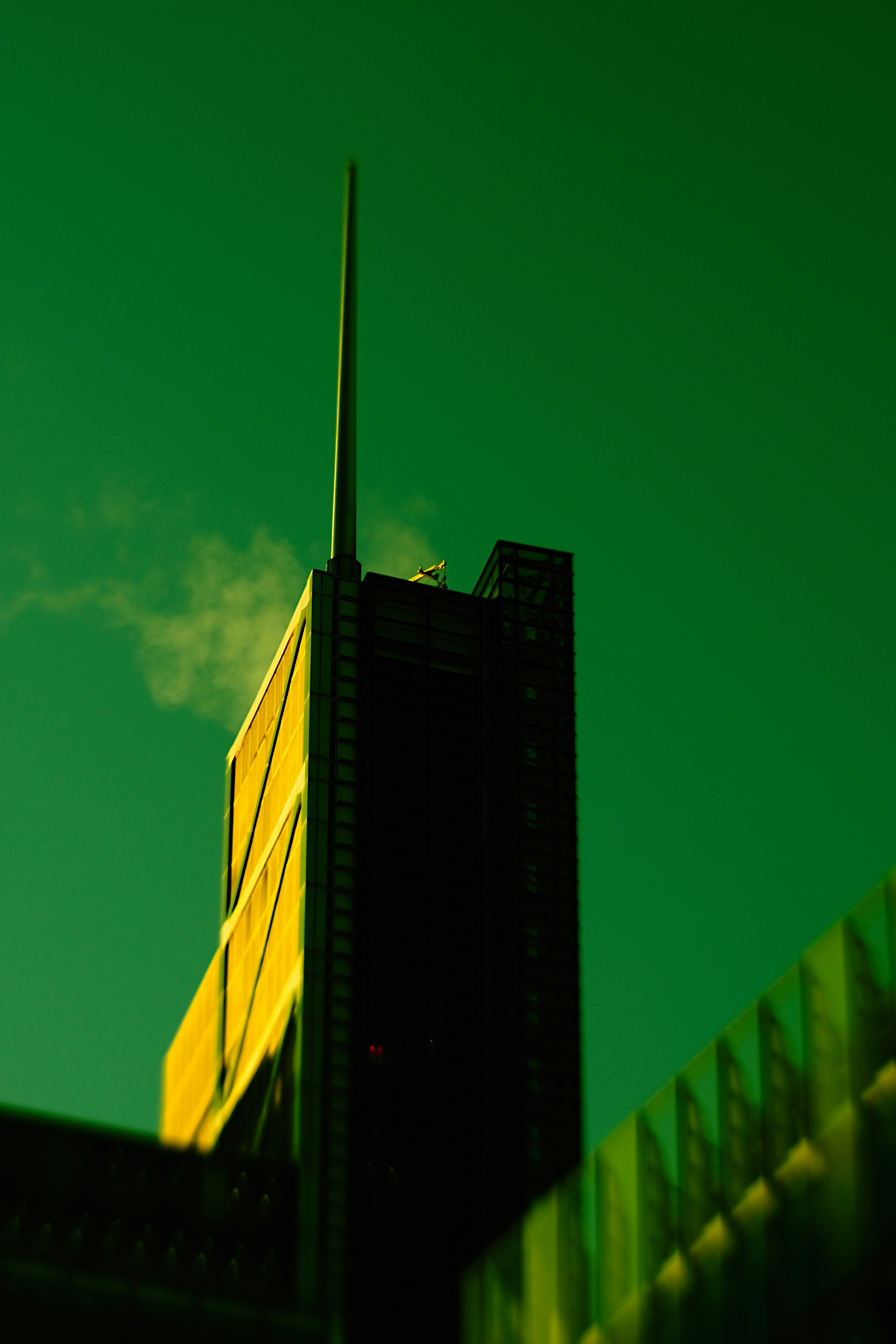 Tall skyscraper against a vibrant green sky
