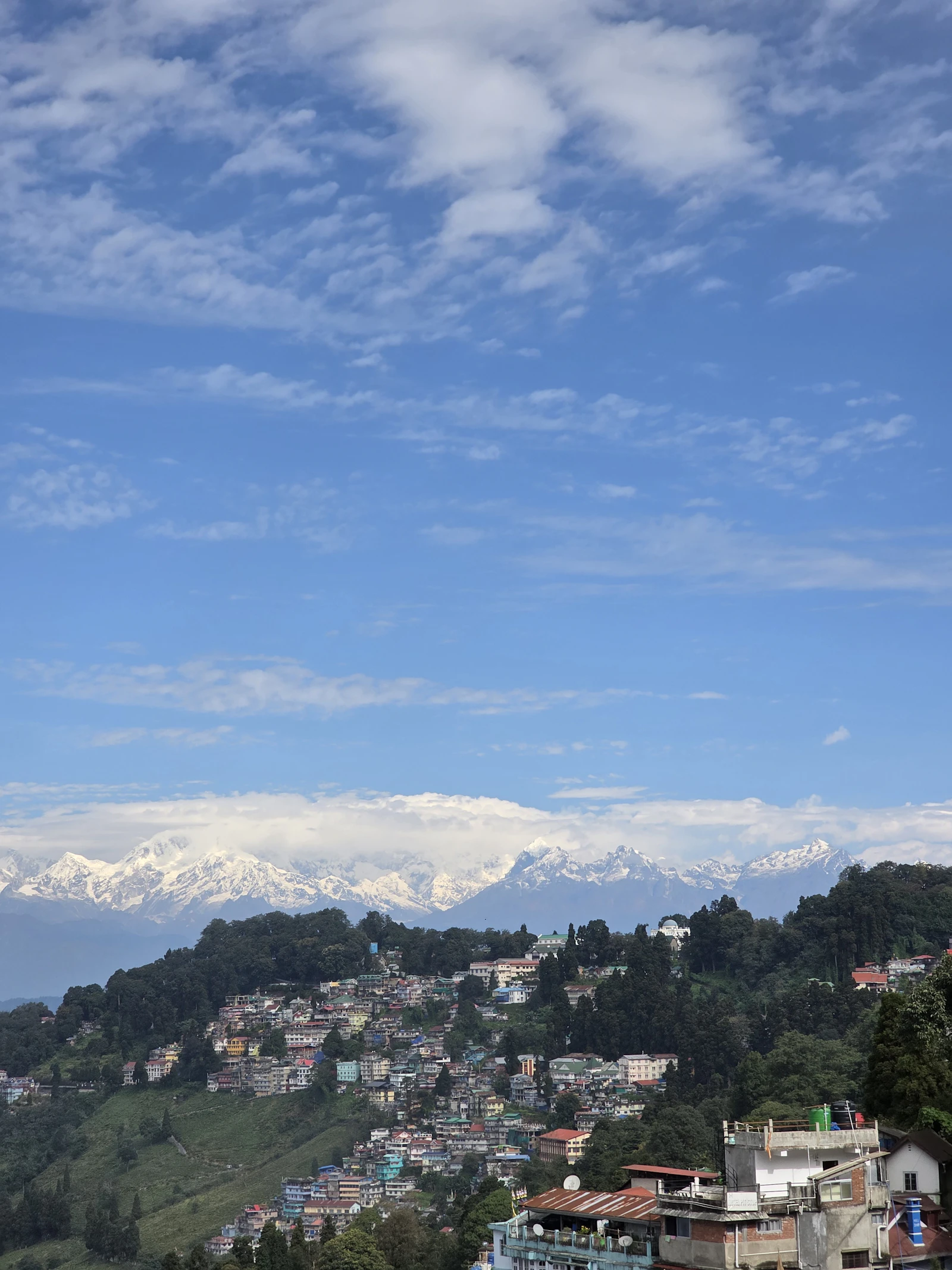 Darjeeling's rooftops stacked down the ridge with the snows of Kanchenjunga on the skyline