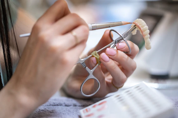 Dentist crafting a dental prosthesis with tools