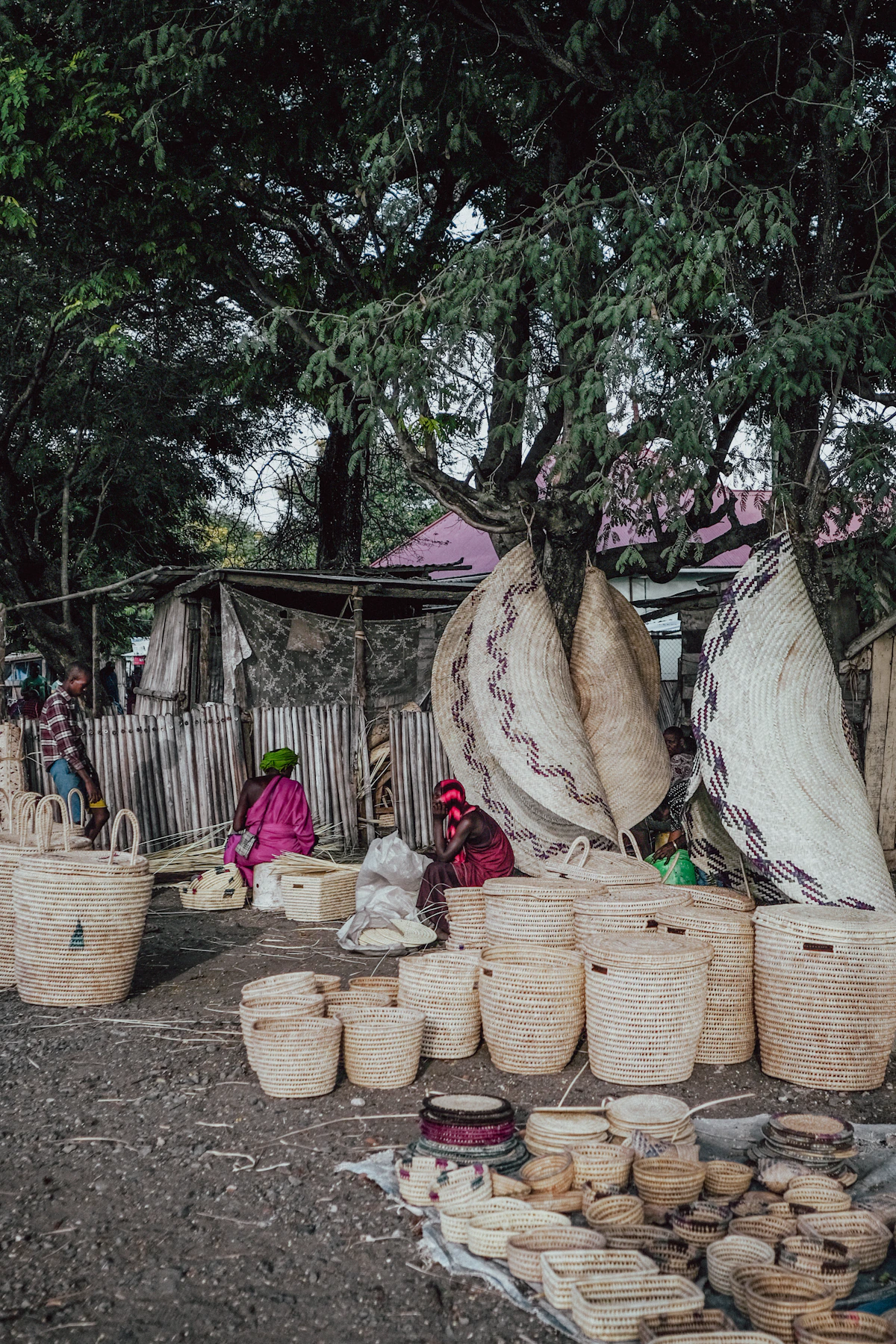 Handwoven baskets and mats displayed at an outdoor market in Arusha