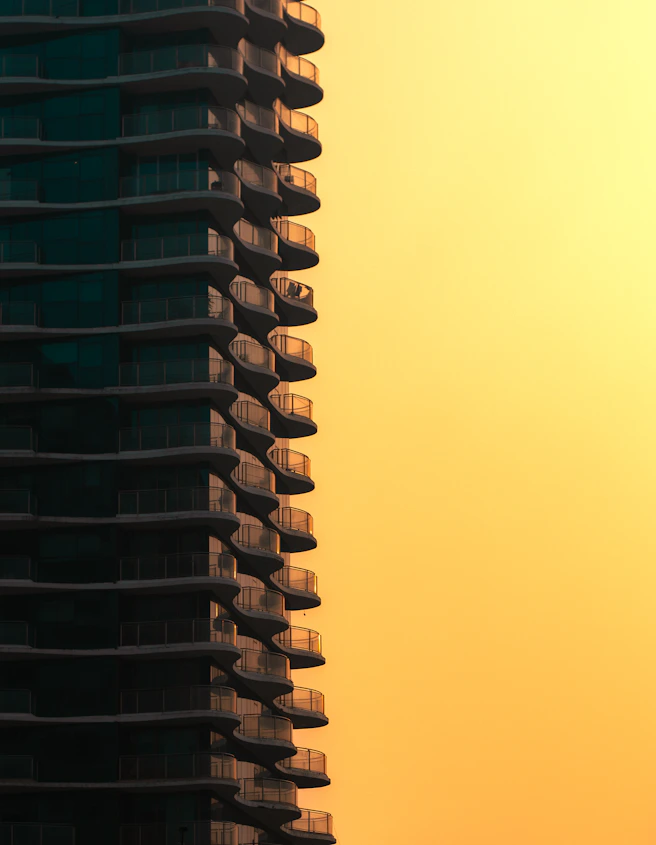 Modern building with balconies against a warm sunset sky