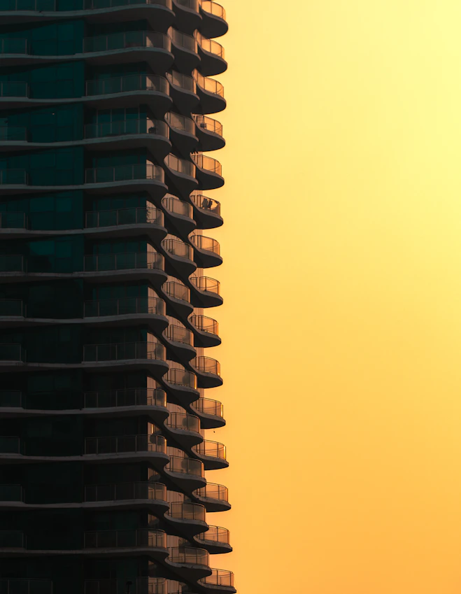 Modern building with balconies against a warm sunset sky