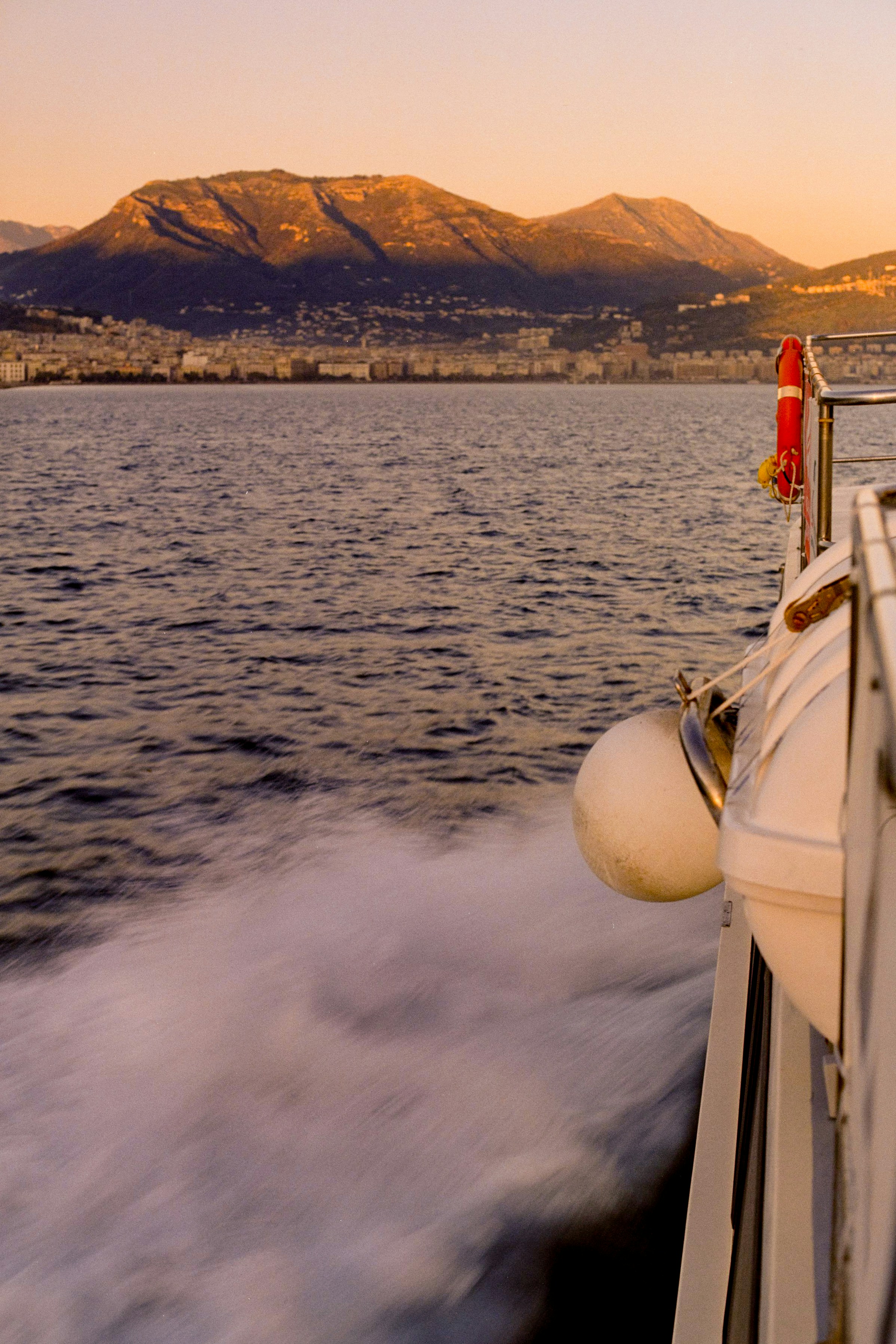 Boot segelnd auf dem Meer mit Bergen im Hintergrund