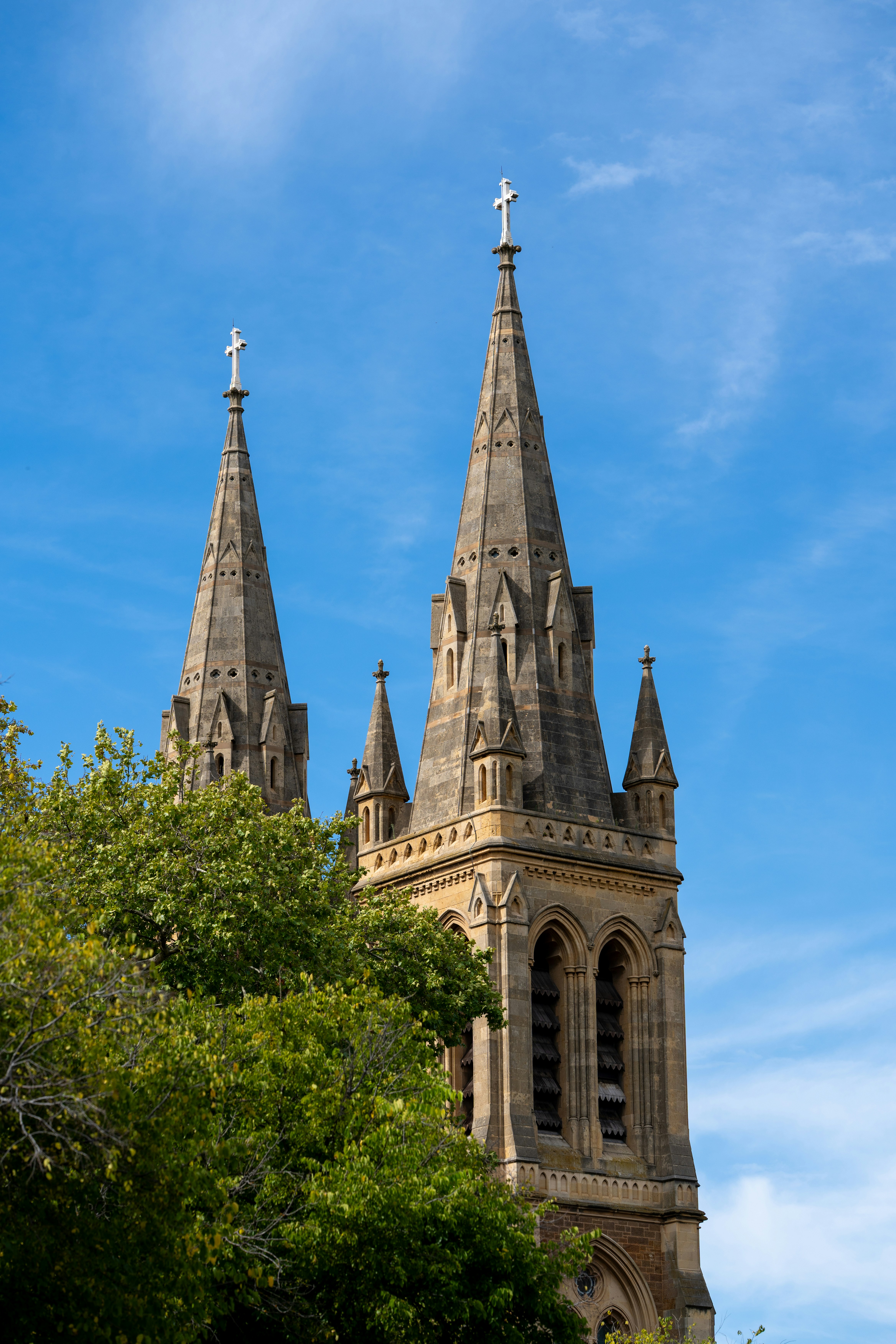 Deux flèches d’église s’élèvent sous un ciel bleu clair.