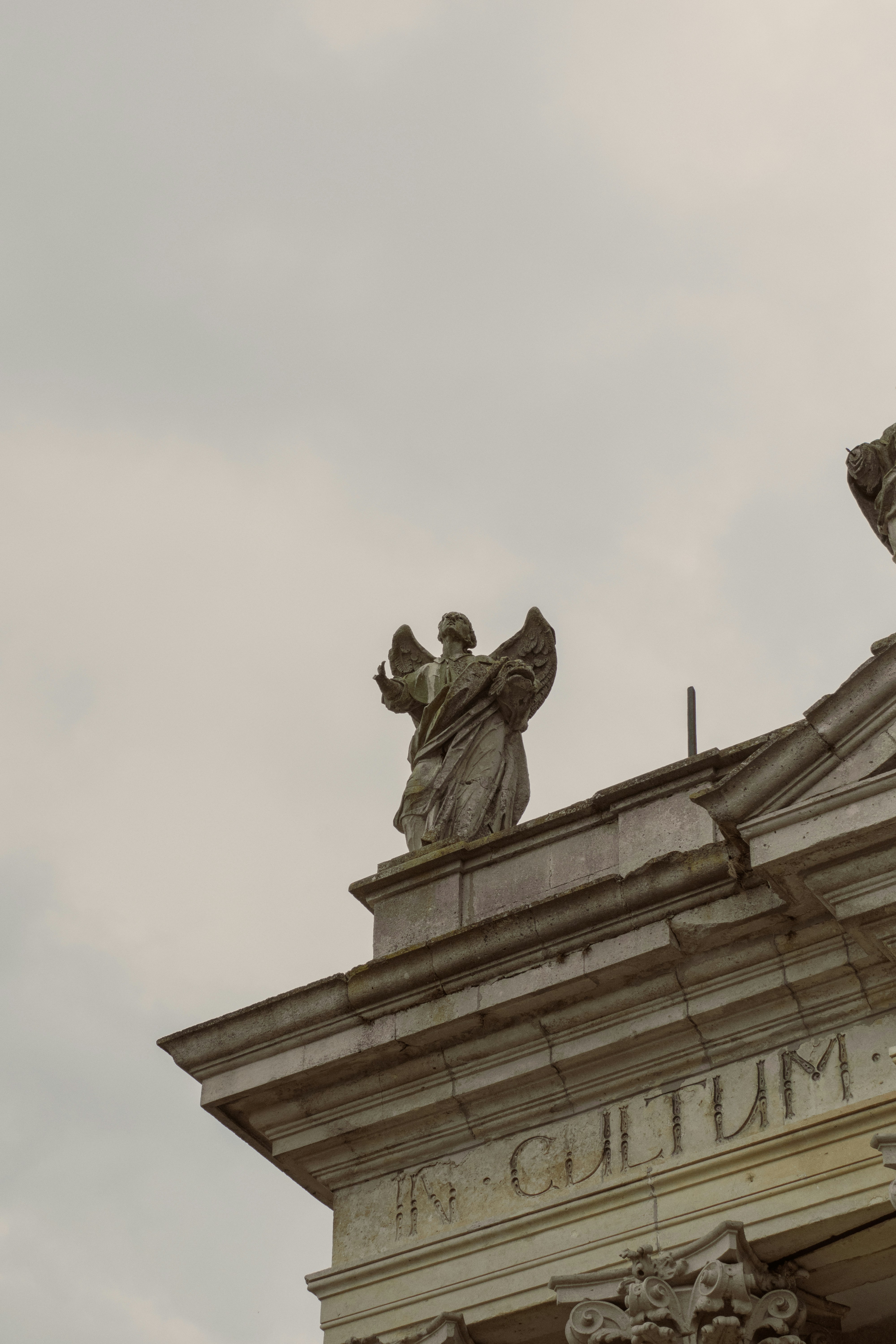 Estatua de ángel de piedra en la fachada de un edificio