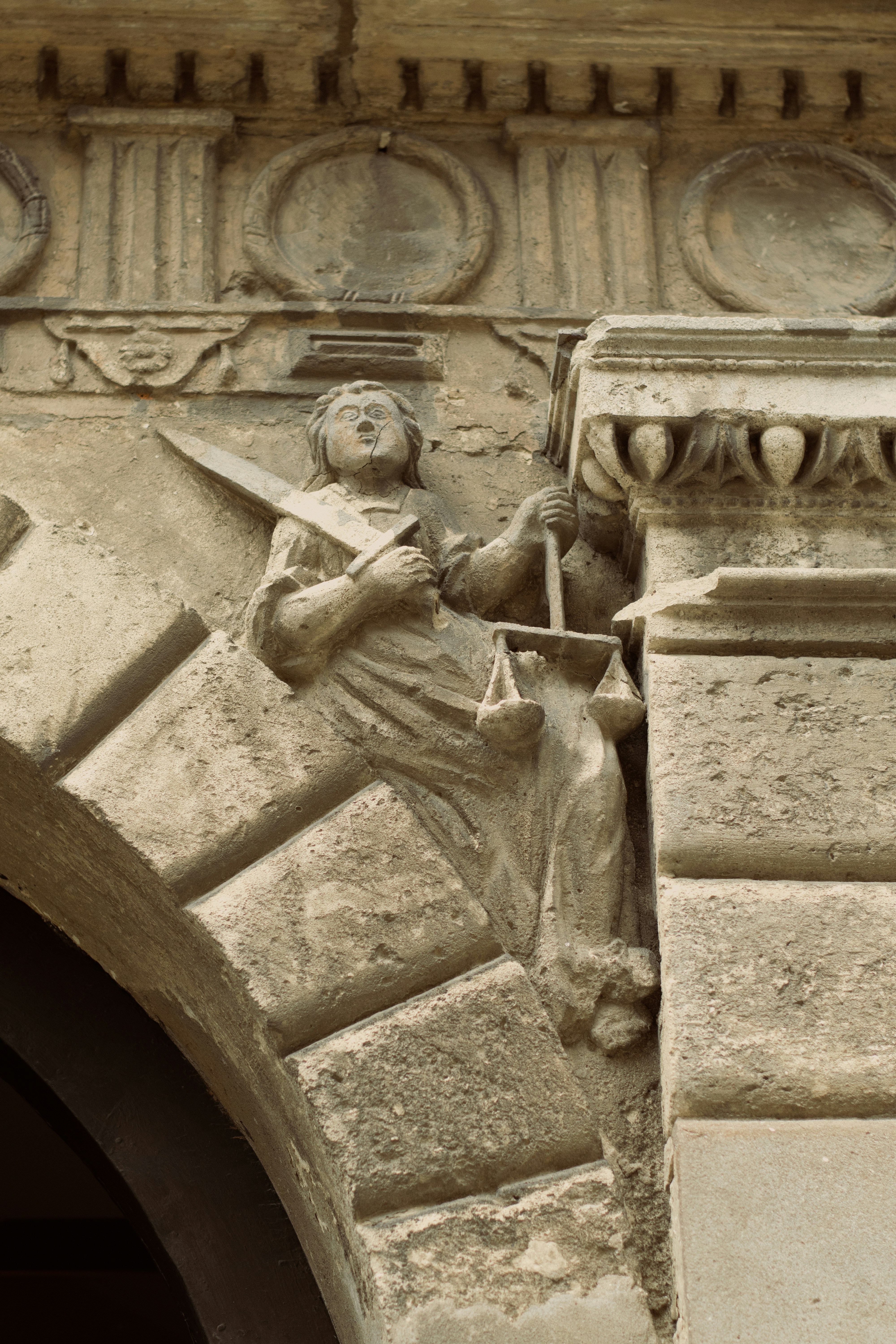 Talla en piedra de la dama de justicia con espada y balanza.
