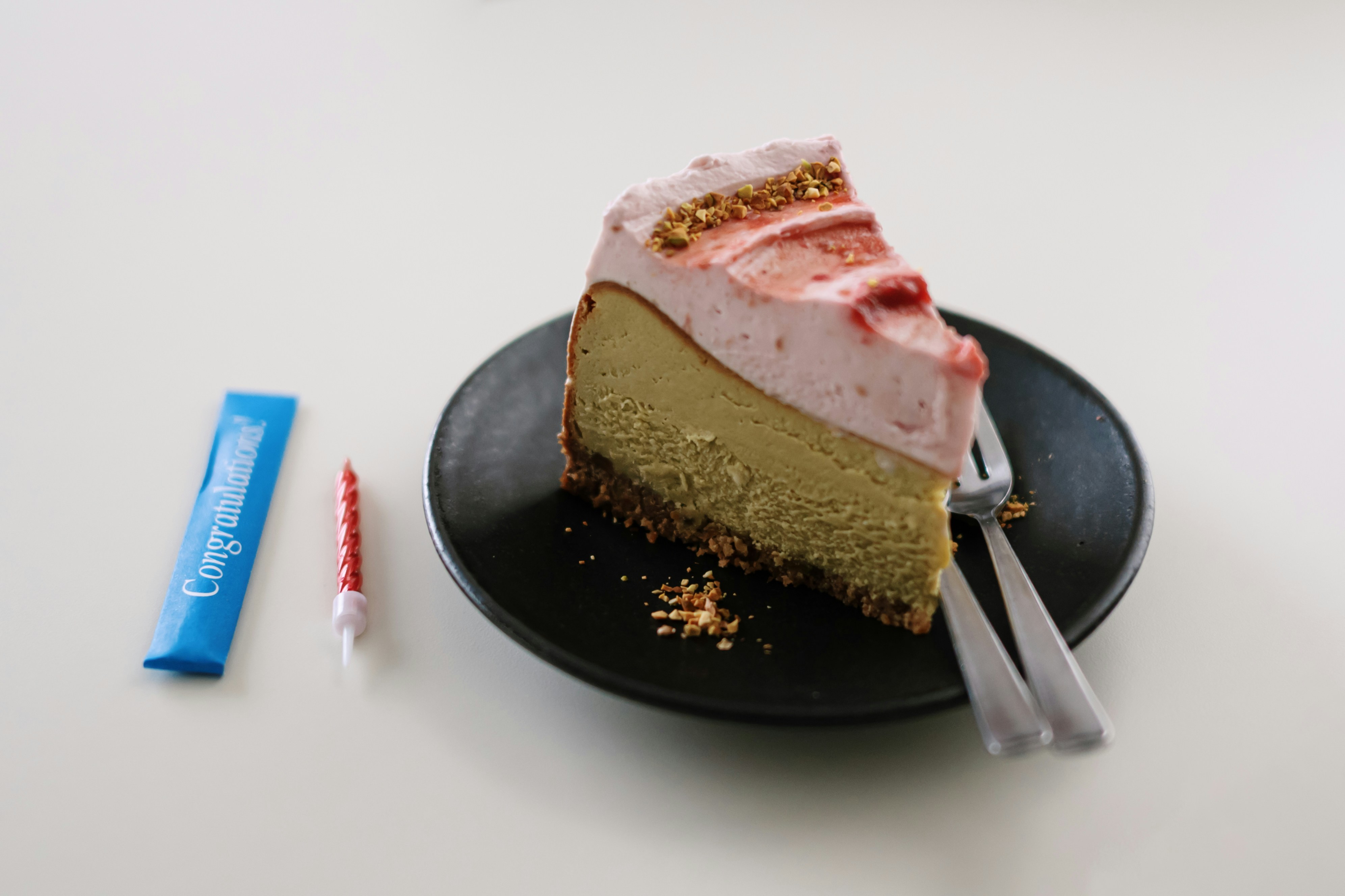Slice of cheesecake with strawberry topping and candle