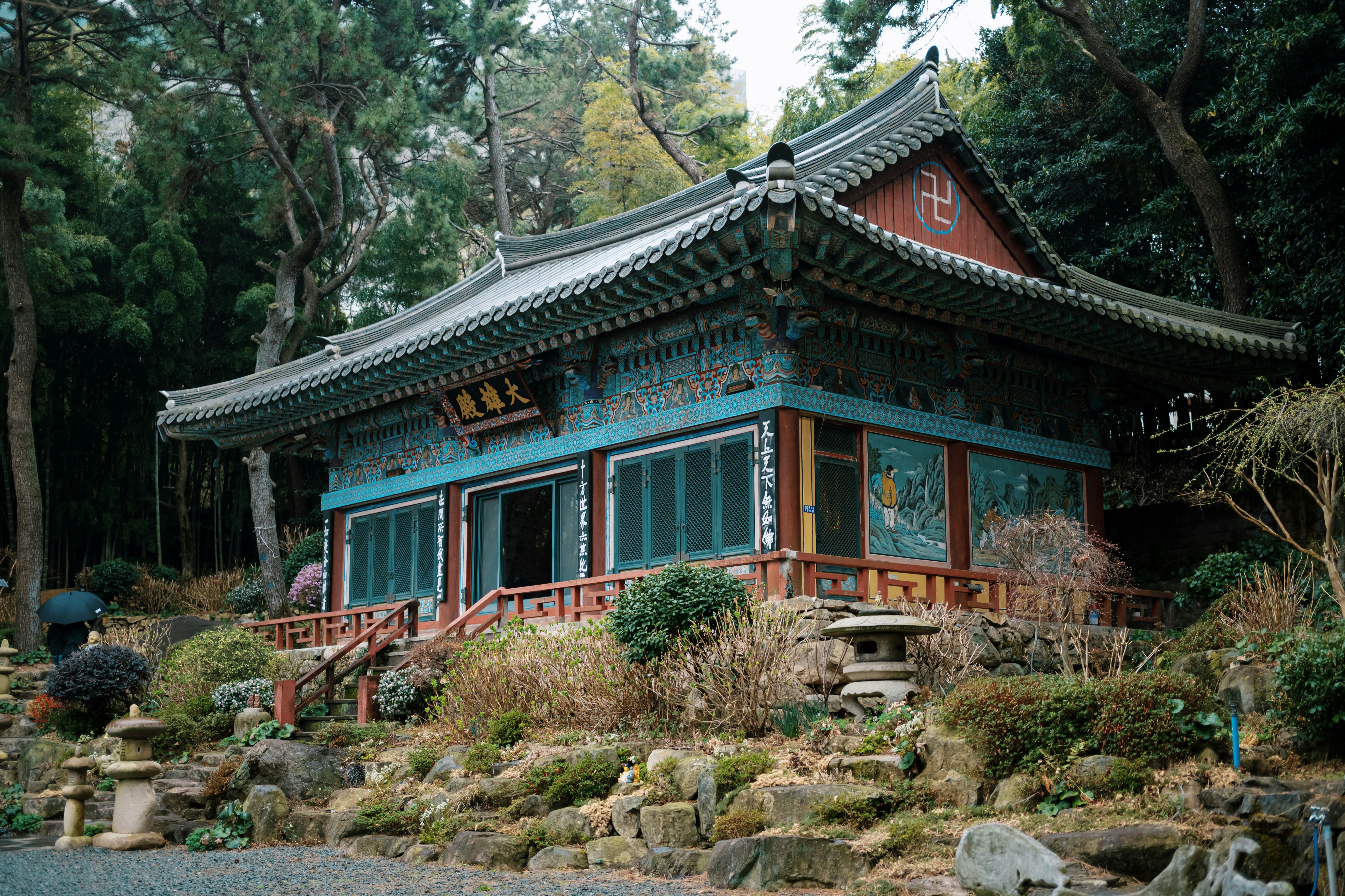 Ornate temple building surrounded by lush greenery and rocks