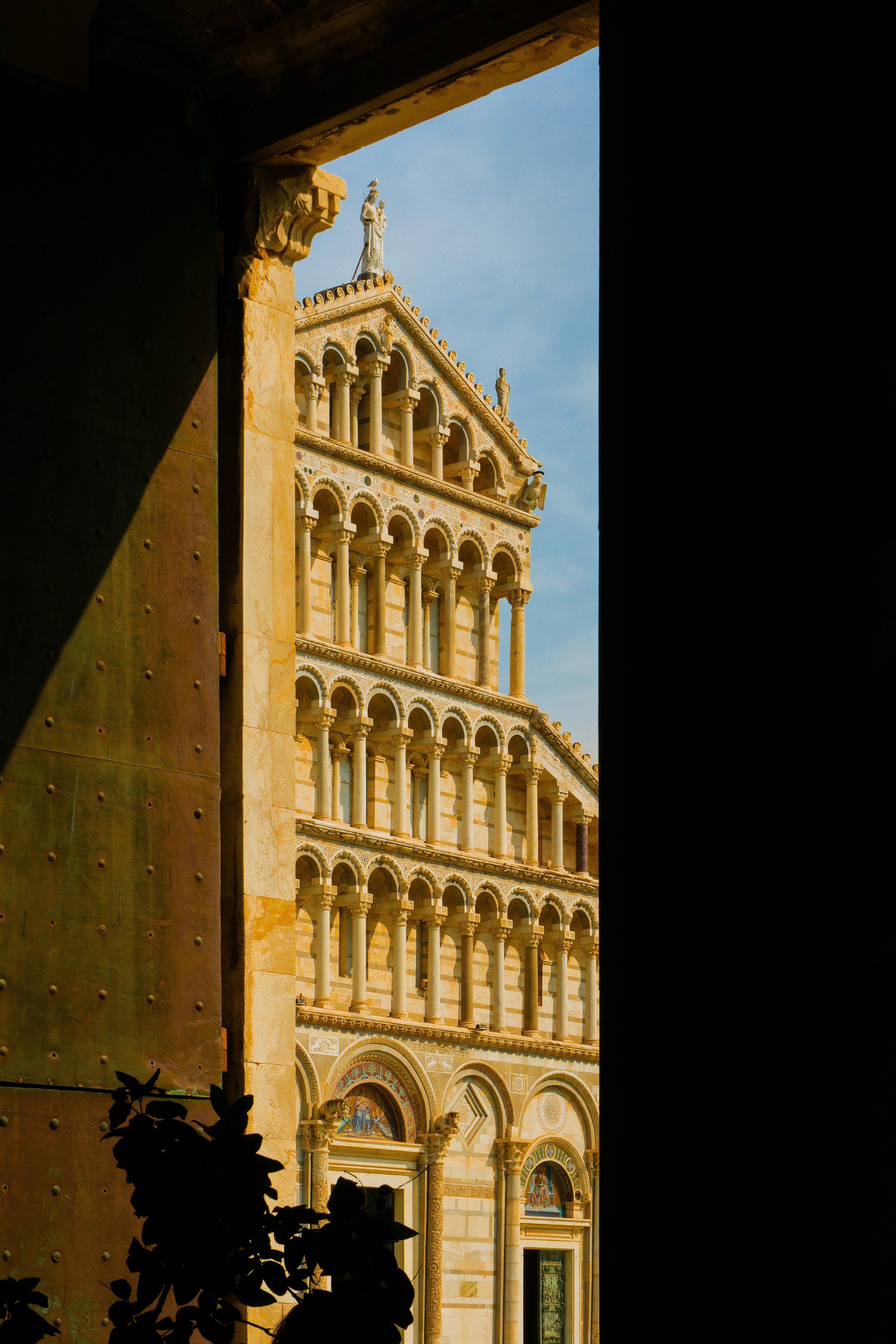 Facciata ornata della cattedrale vista attraverso una porta aperta.