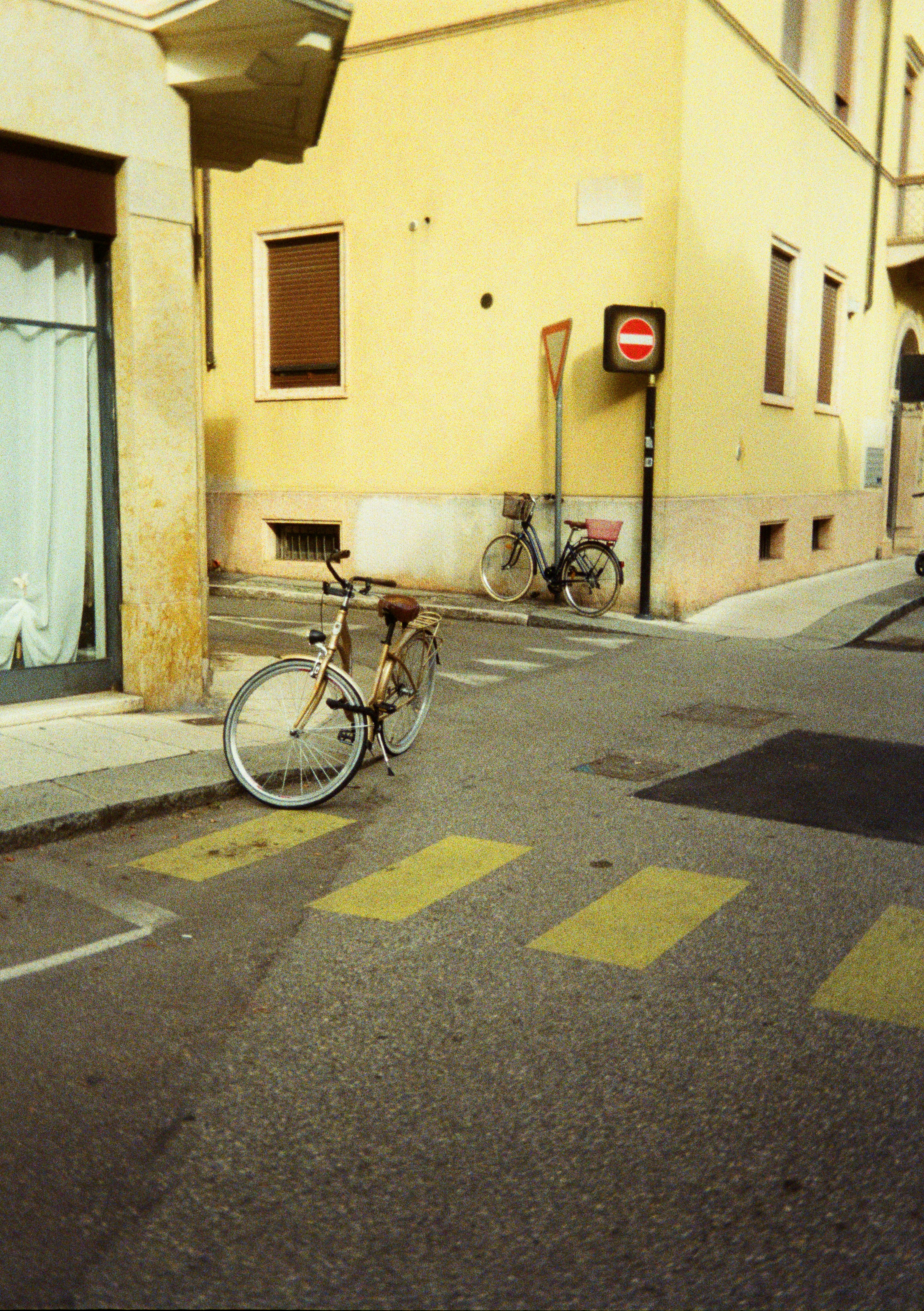 Due biciclette parcheggiate vicino a un edificio giallo.