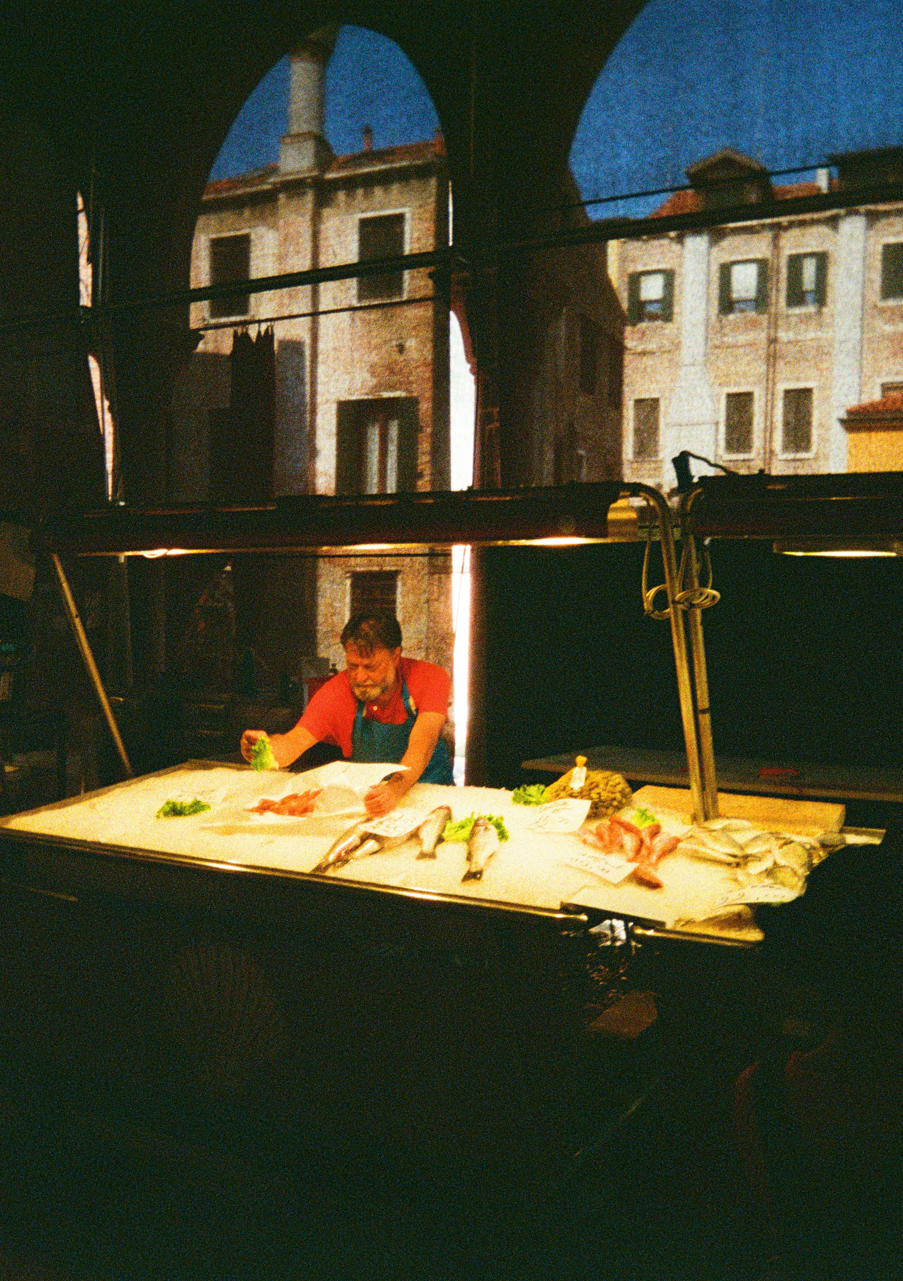Un uomo prepara il pesce a una bancarella del mercato.