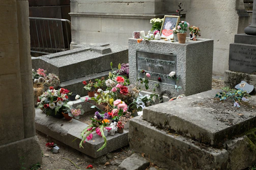 A grave adorned with flowers and a framed picture.