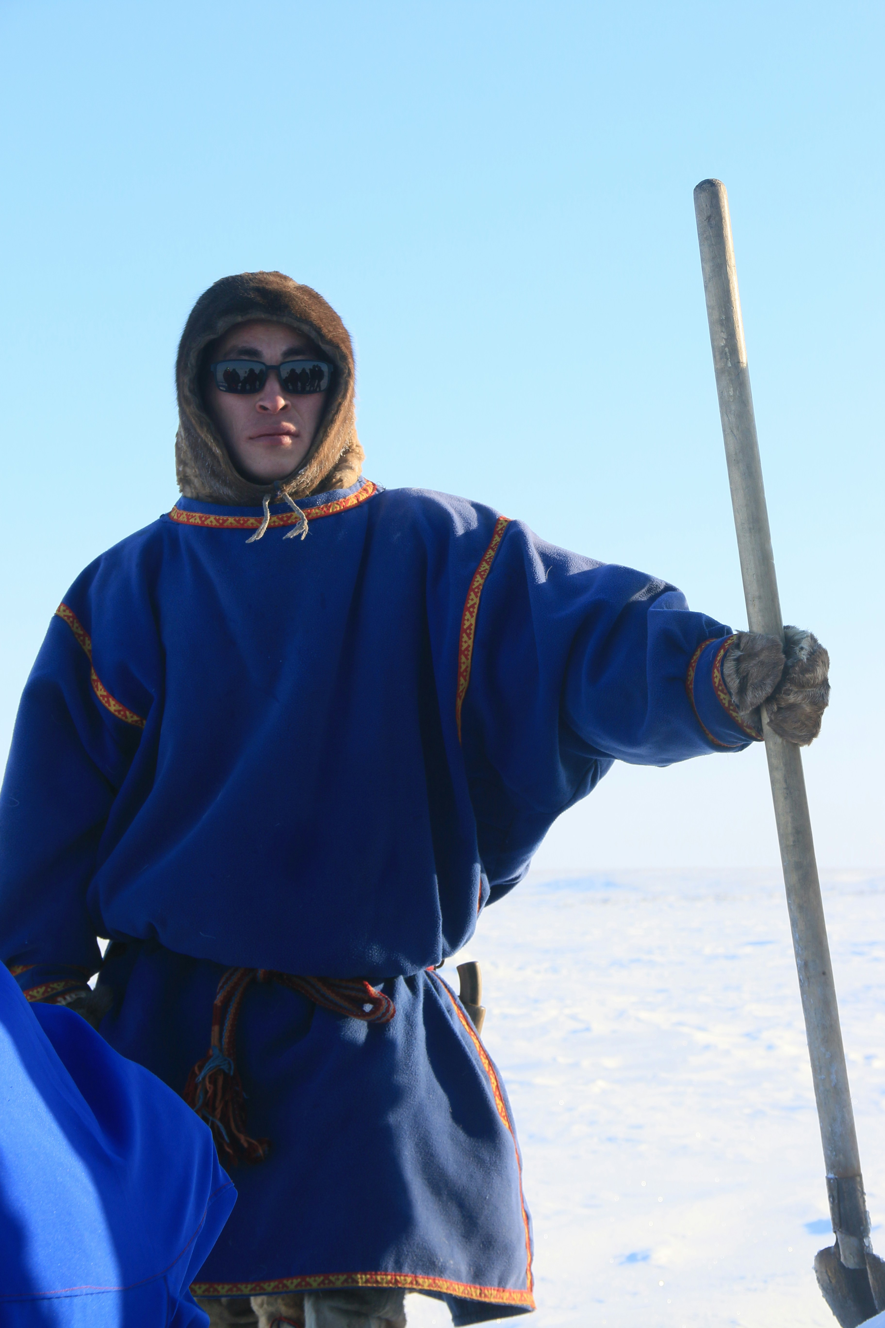 Hombre con ropa tradicional sosteniendo una pala en la nieve