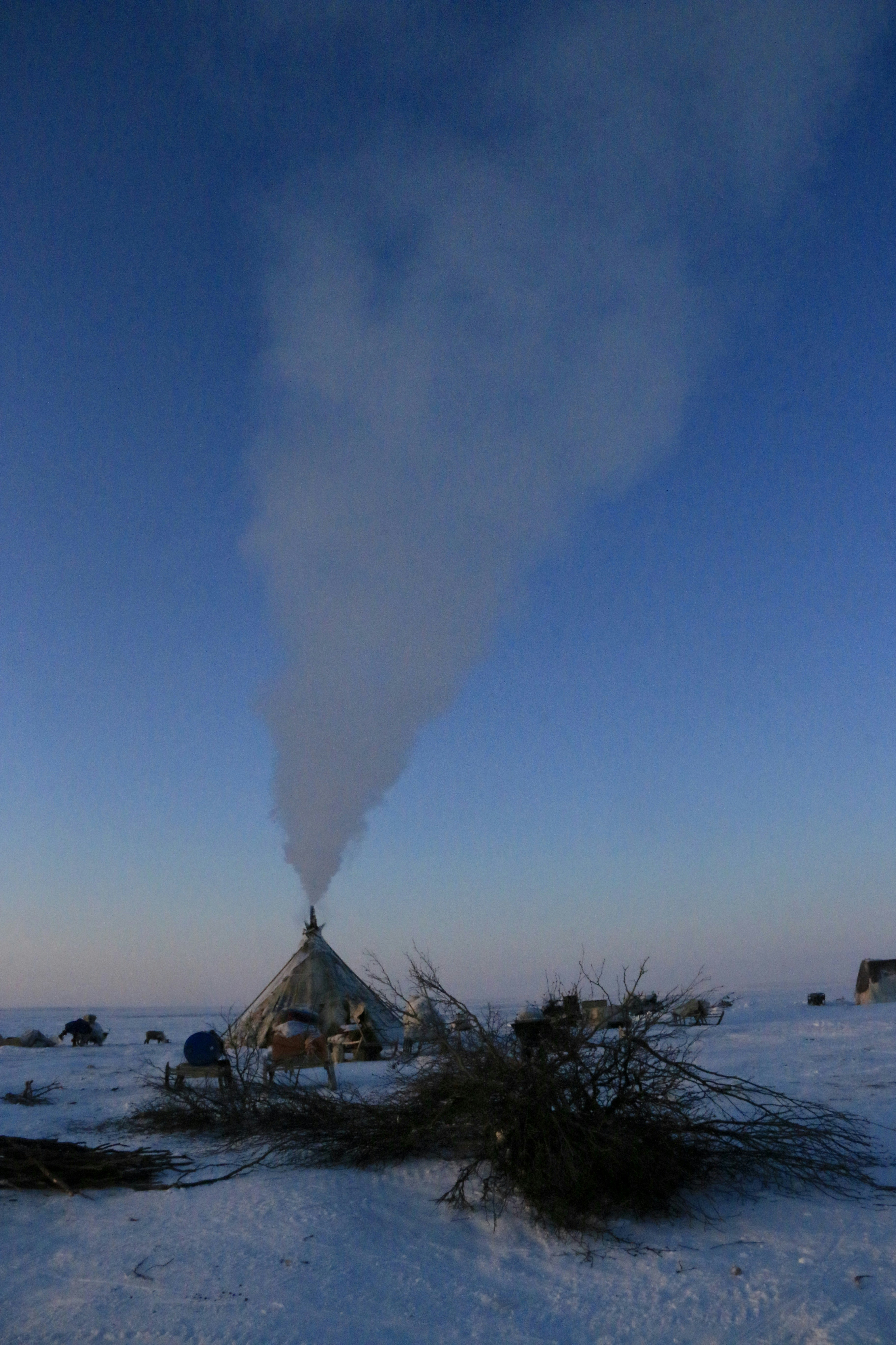 Il fumo si alza da un'abitazione in un paesaggio innevato.