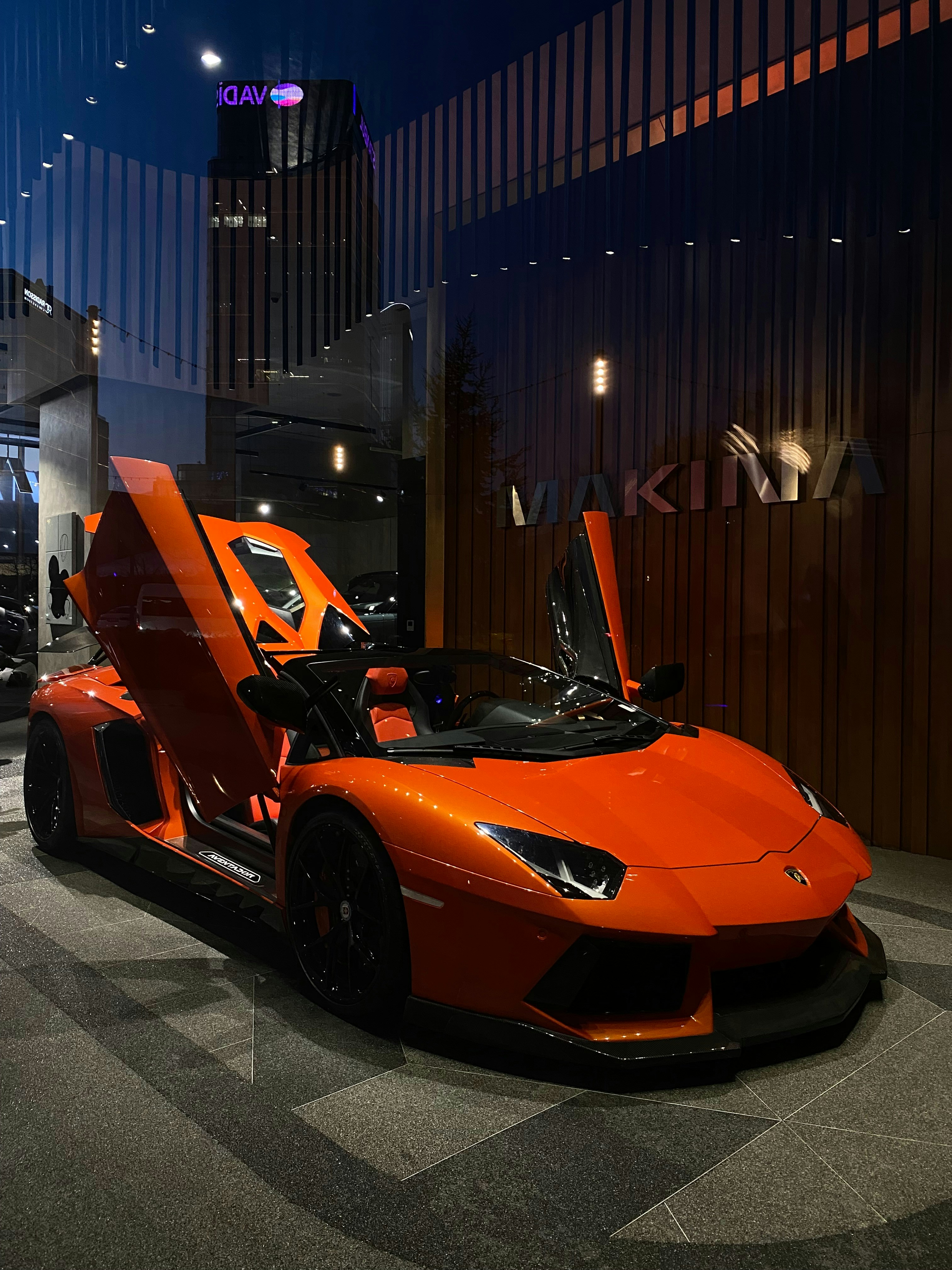 An orange sports car with doors open