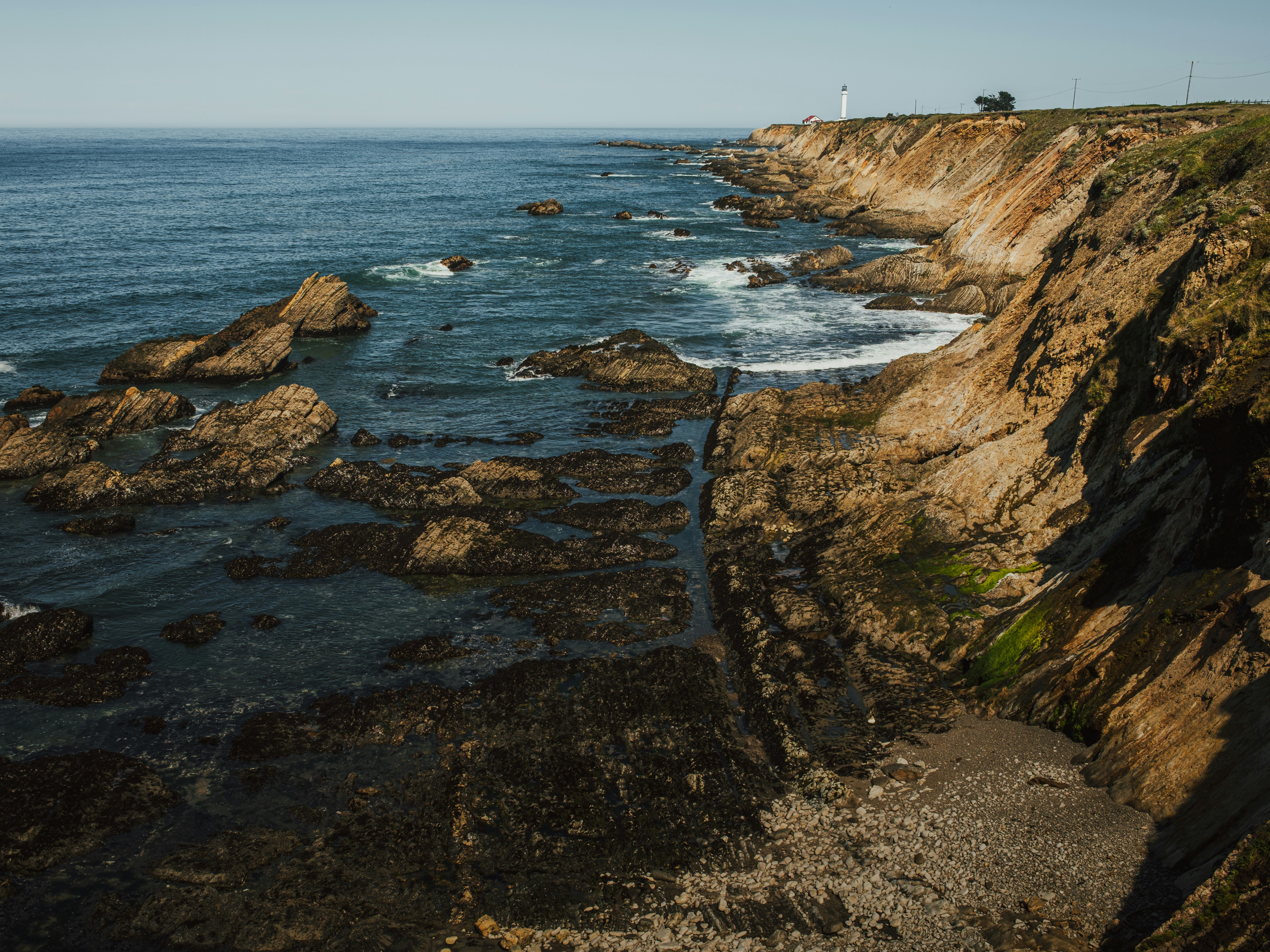 Rocky coastline with waves crashing against cliffs.