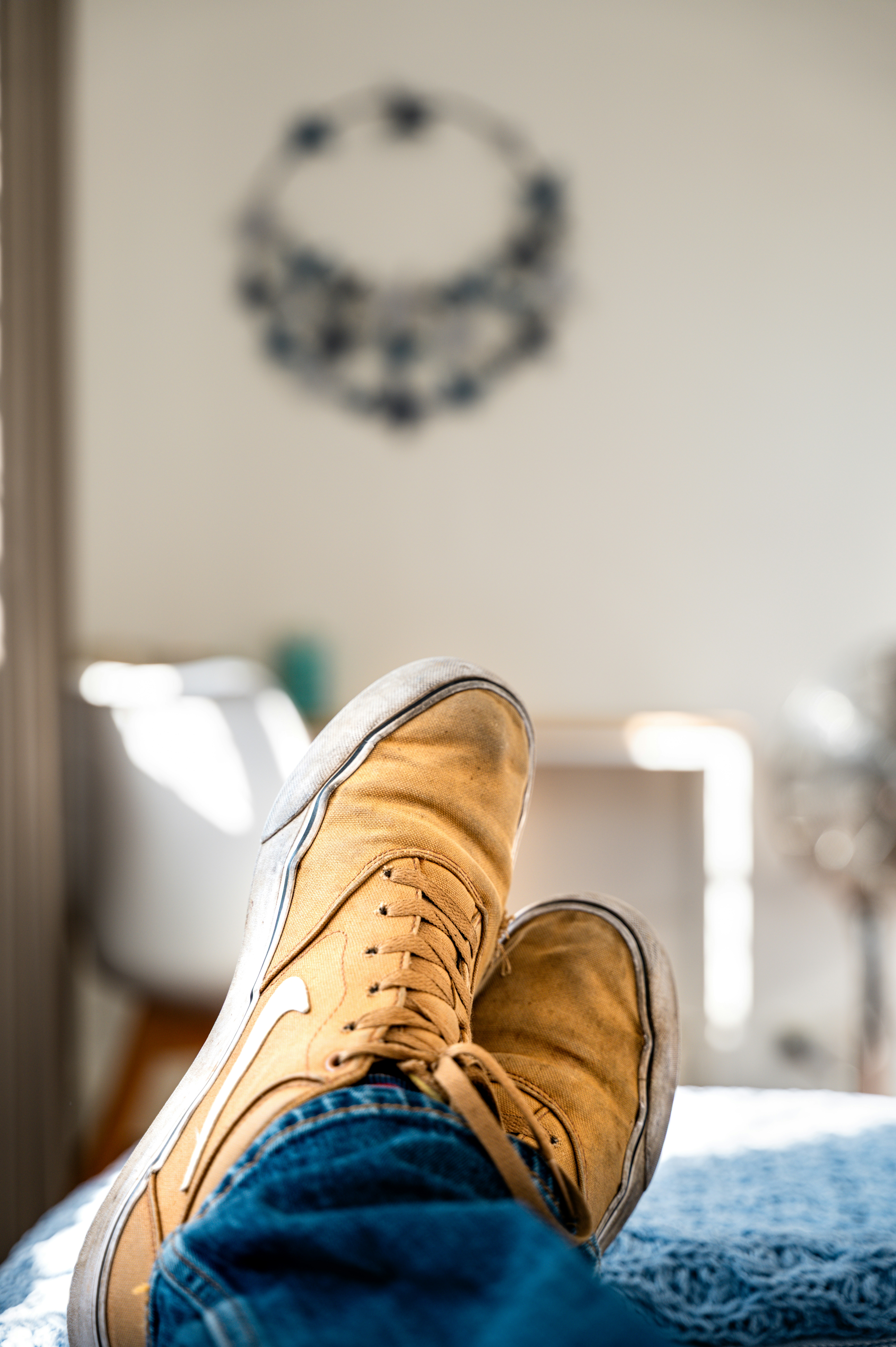 I piedi di una persona con scarpe da ginnastica gialle appoggiate su una coperta blu.