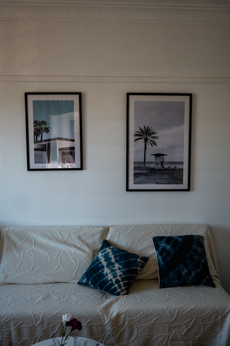 Sofa with decorative pillows and framed beach art