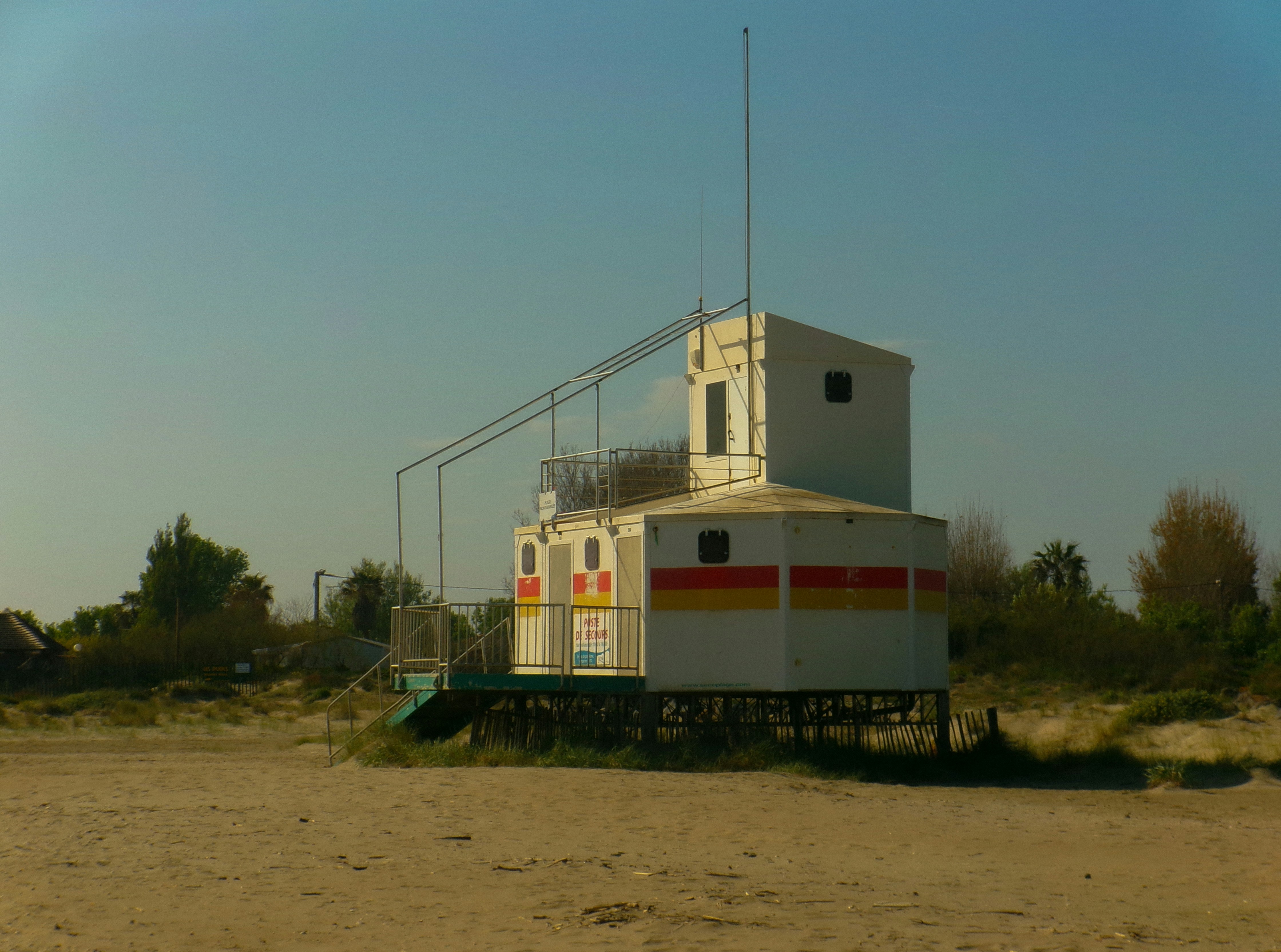 A white lifeguard station on a sandy beach