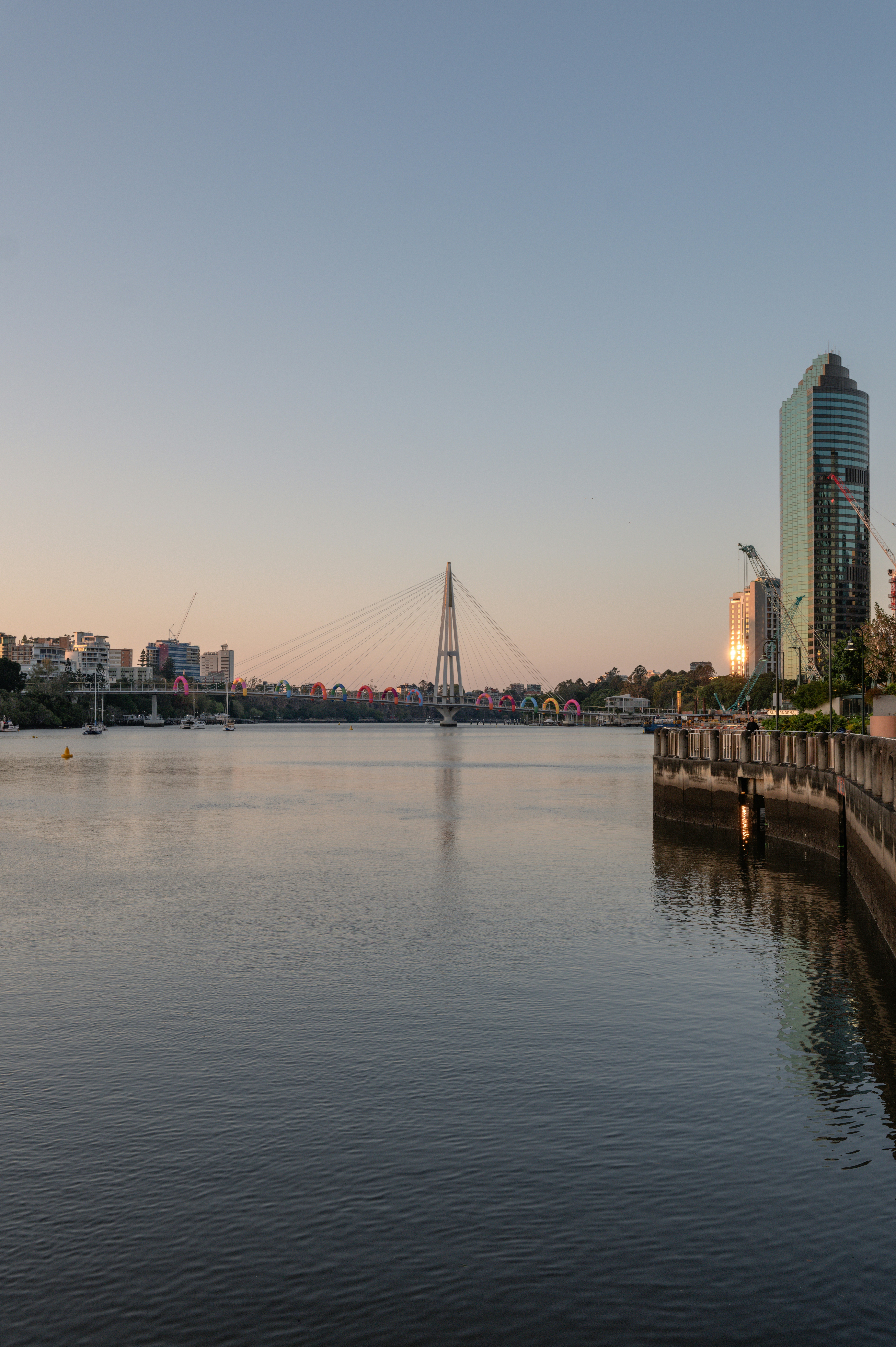 Horizonte da cidade com uma ponte sobre águas calmas ao entardecer