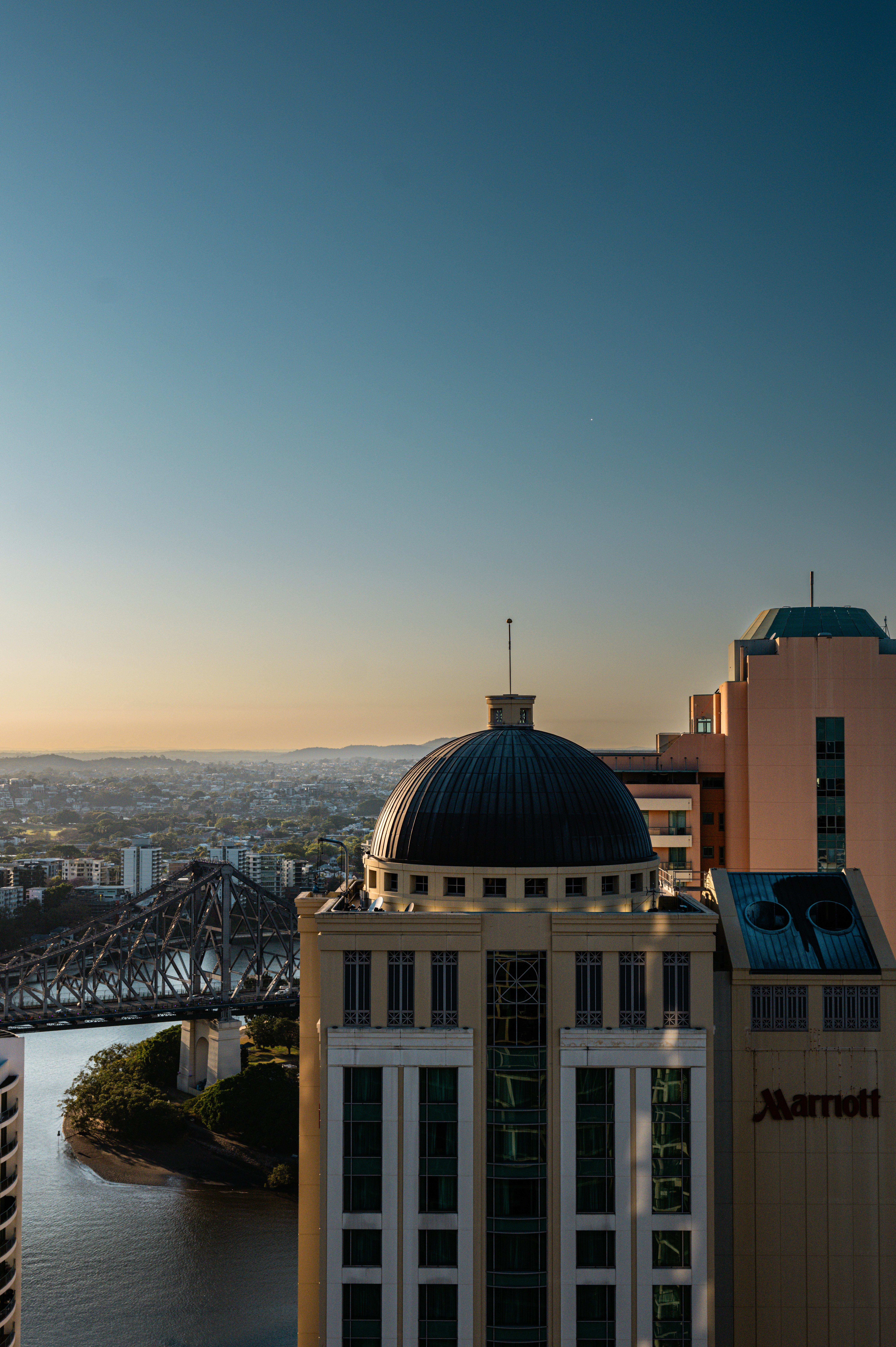 Horizonte da cidade com prédio em cúpula e ponte ao pôr do sol