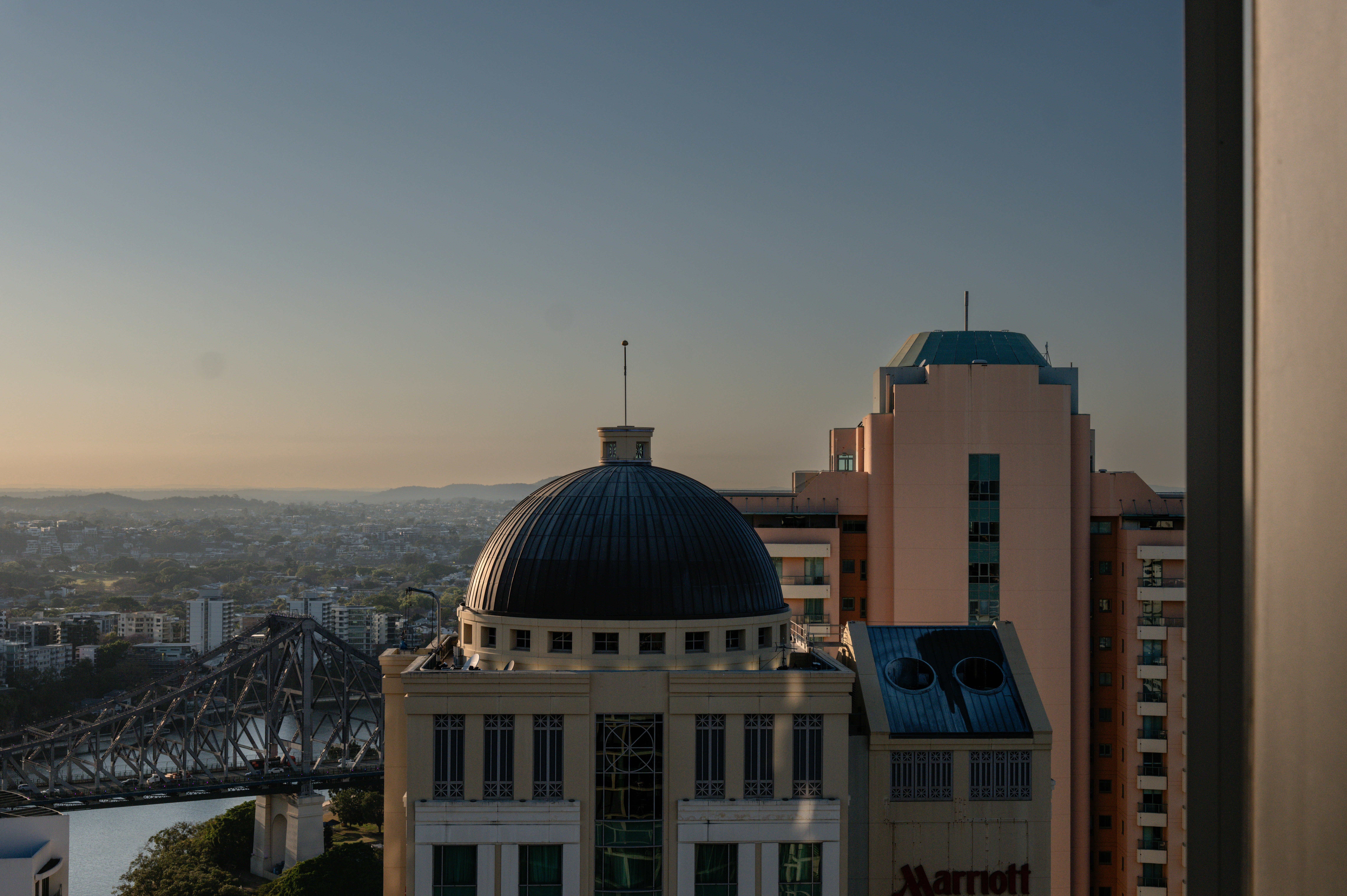 Horizonte da cidade com construção em cúpula e ponte ao pôr do sol