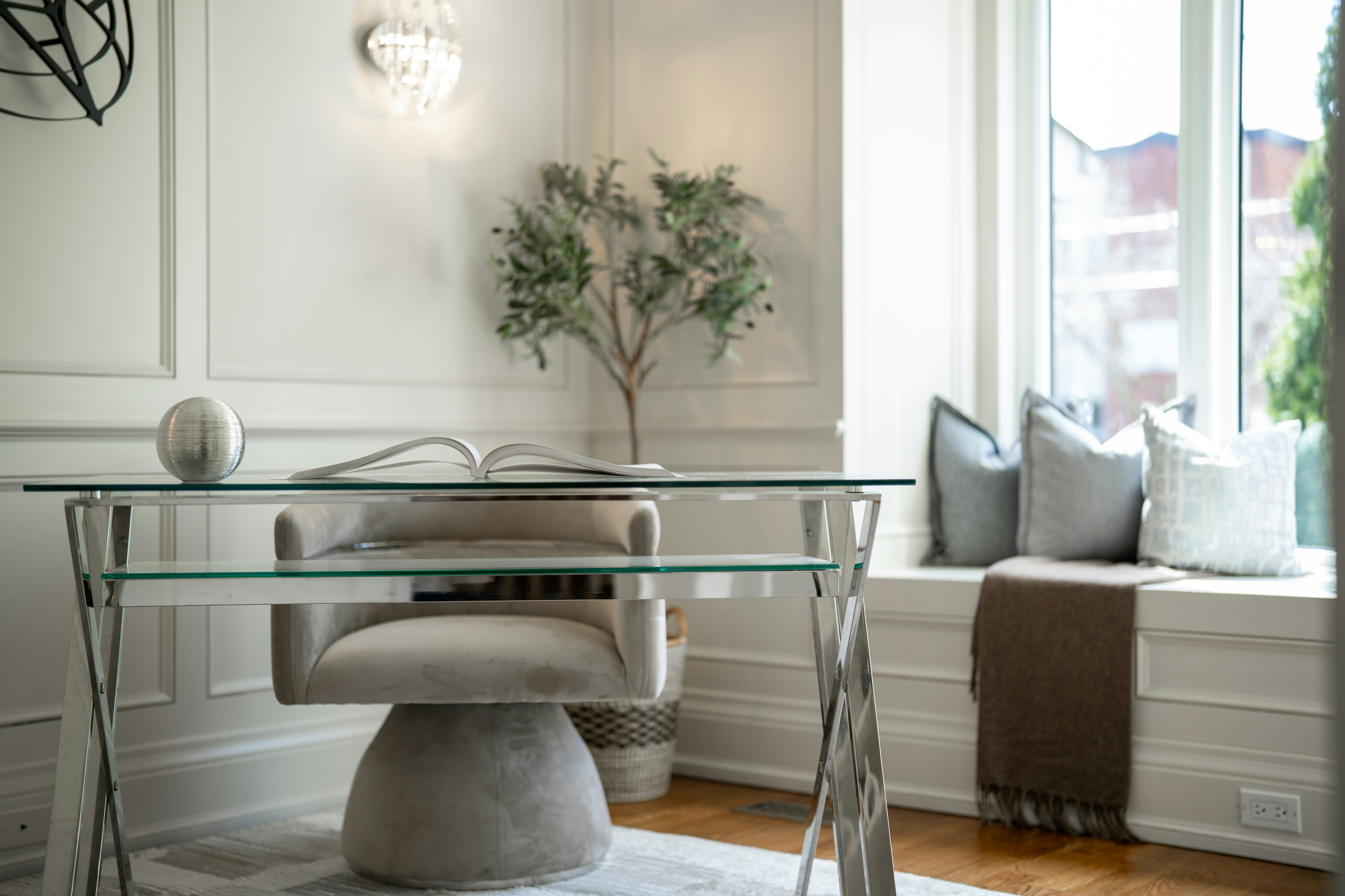 Elegant home office with glass desk and comfortable chair.