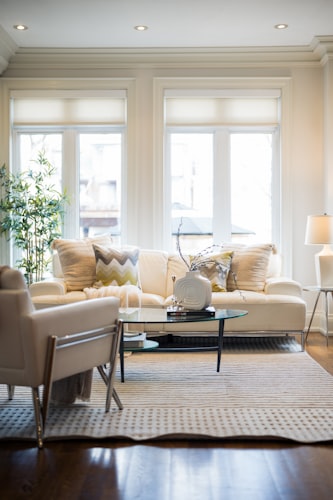 Bright modern living room interior with comfortable sofa and large windows