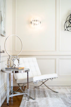 Modern white chair with metallic accents and side table.