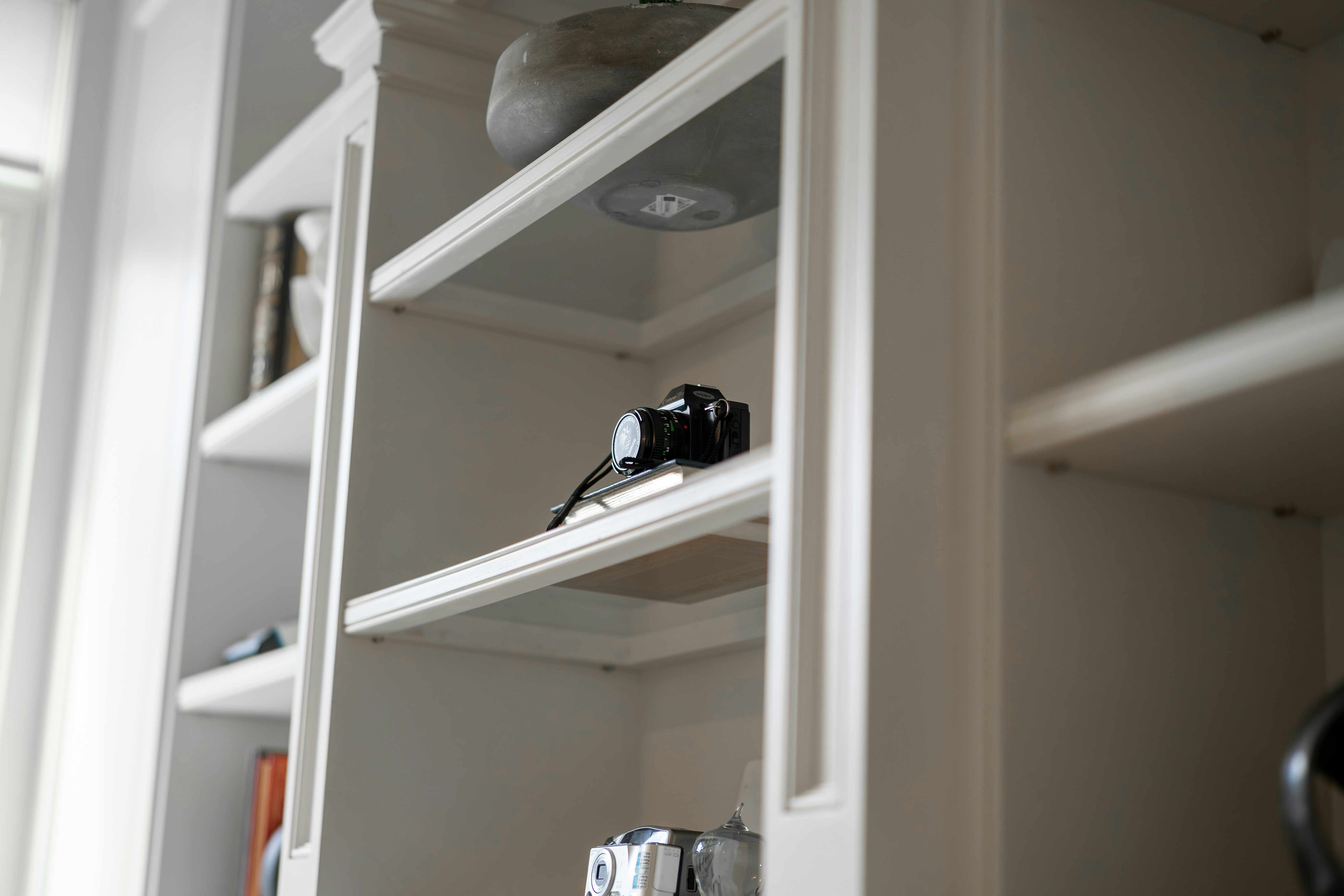Ventilatie Leiden — A camera rests on a white bookshelf. — Ventilatie-installateur in Leiden: WTW, kosten en lokale tip