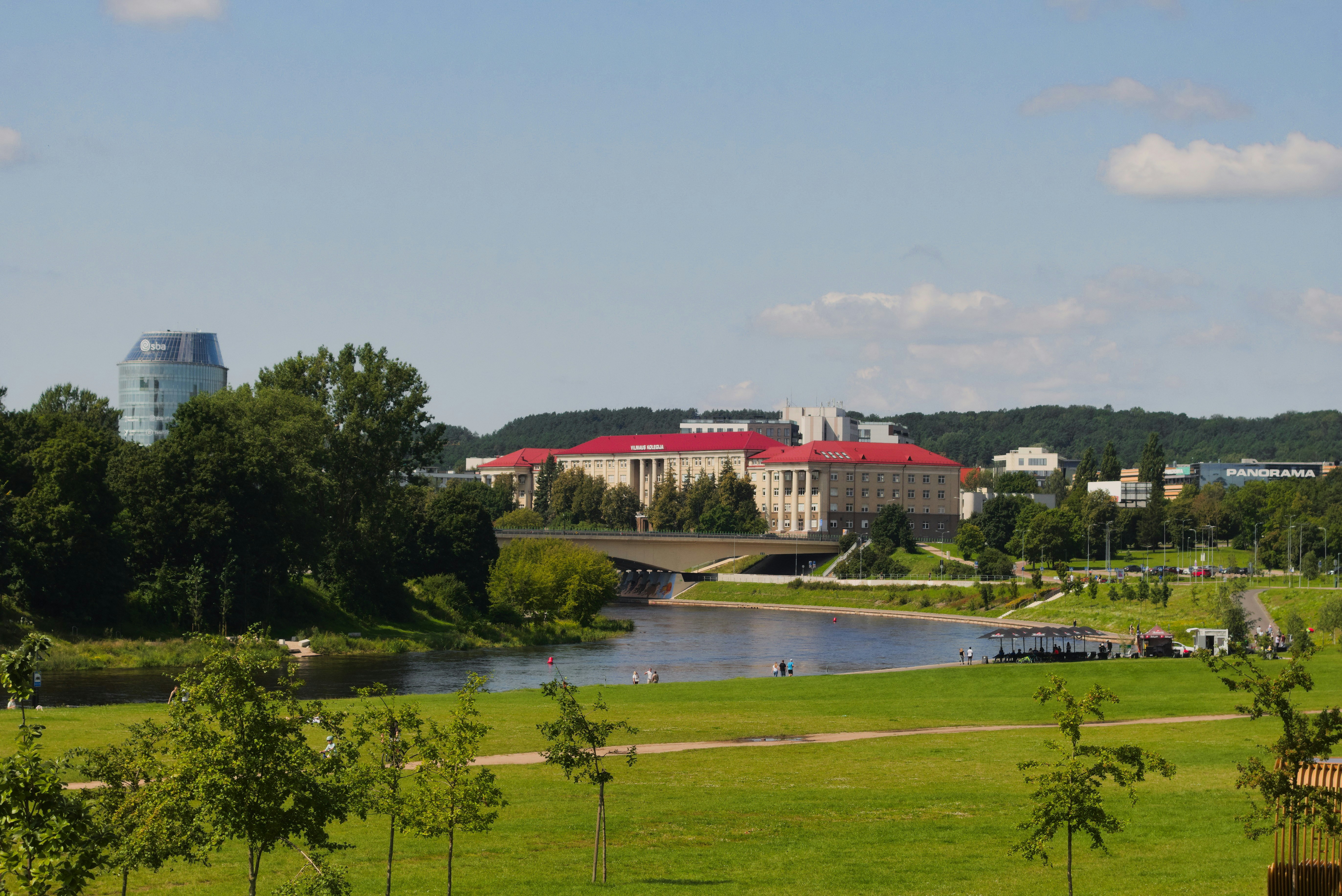 Park with a river and buildings in the distance