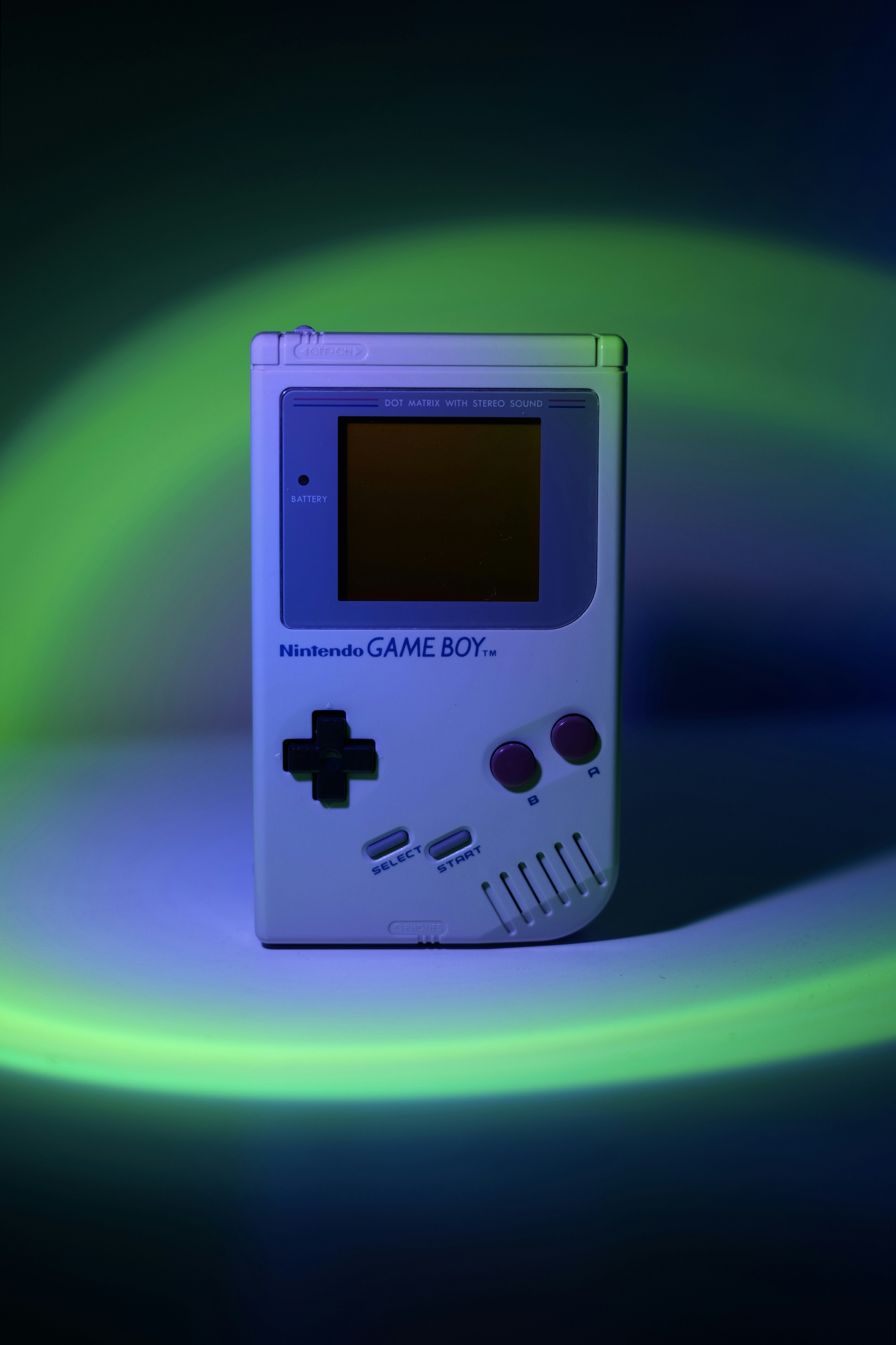A white nintendo game boy with colorful lighting.