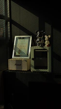 Shadows fall on framed picture and bear figurines.