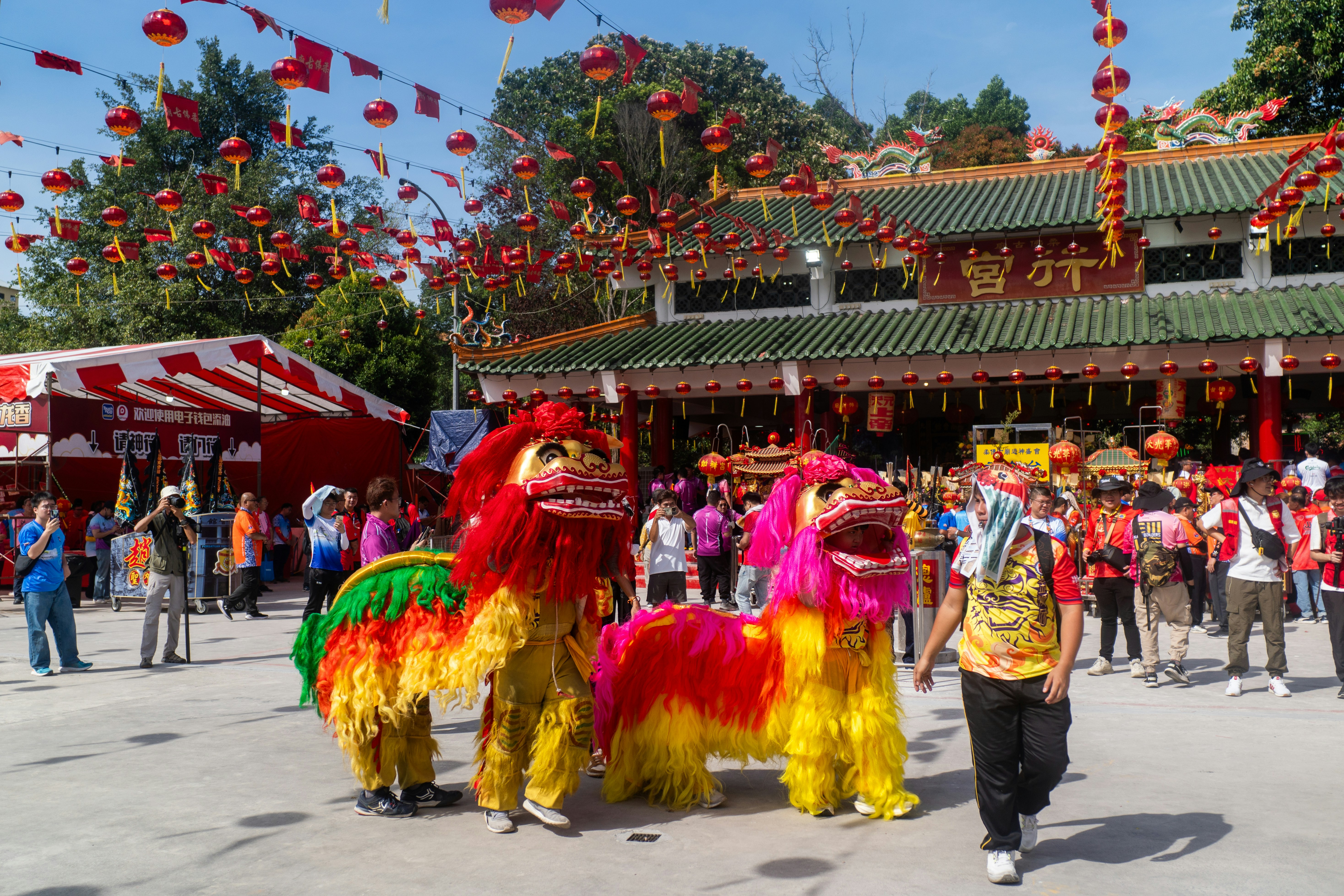 People watch lion dancers during a festival outside a temple.