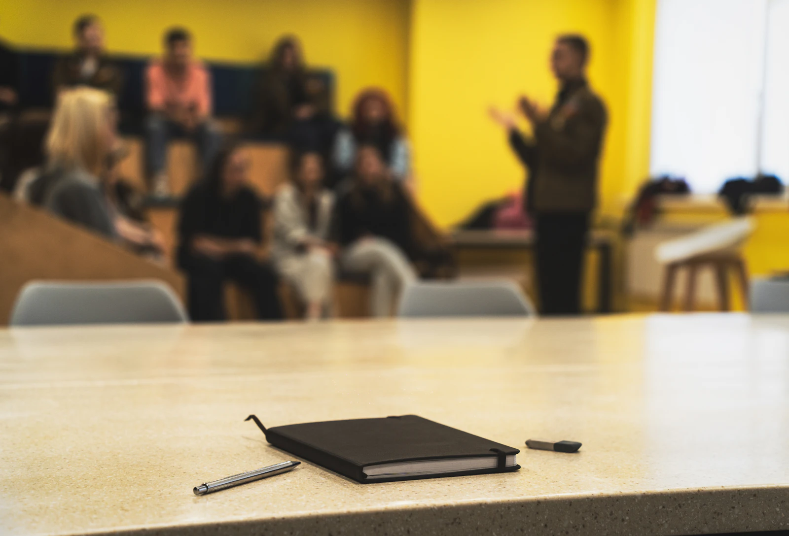 Carnet et stylo au premier plan lors d'une session de formation