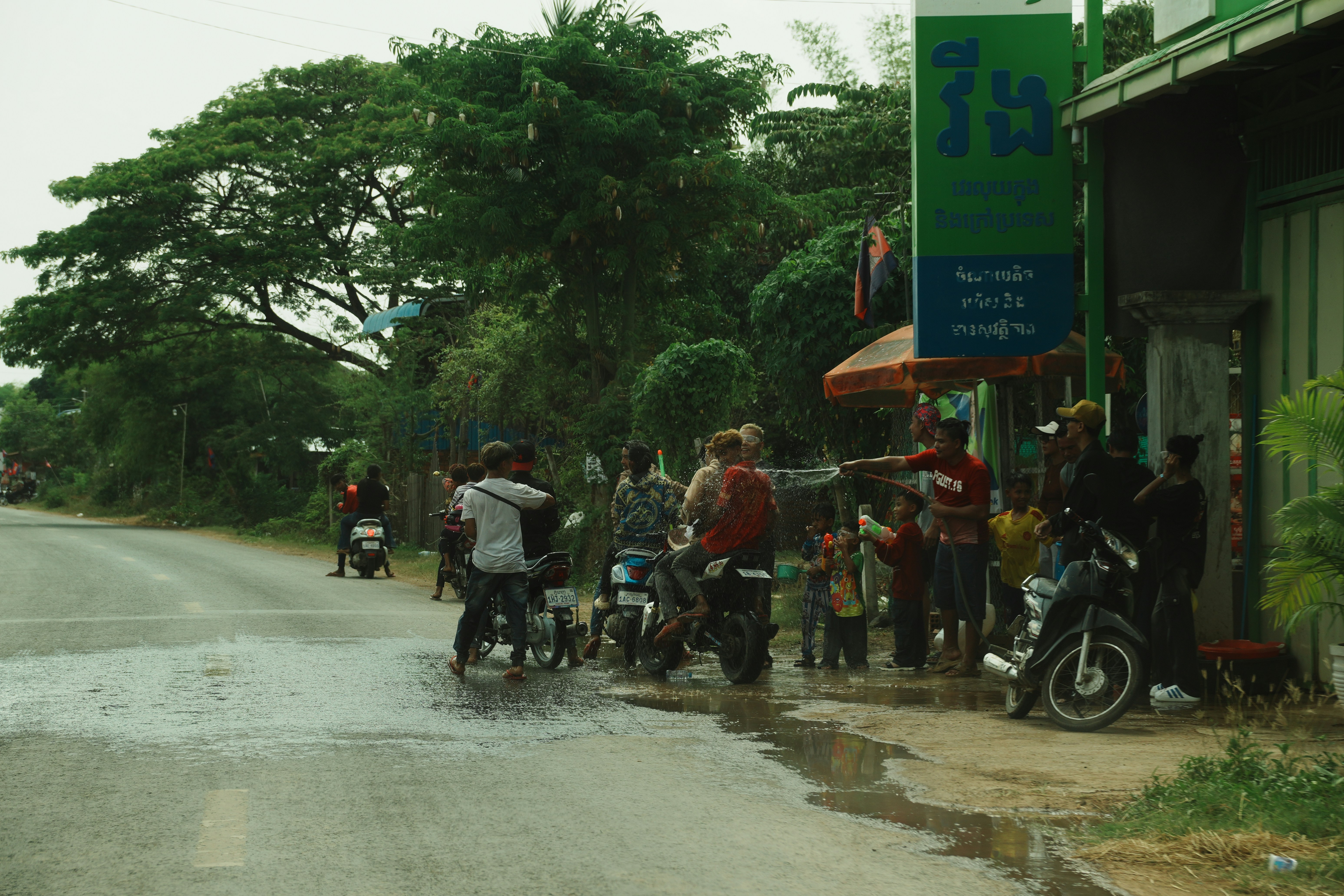 People on motorcycles on a wet street.