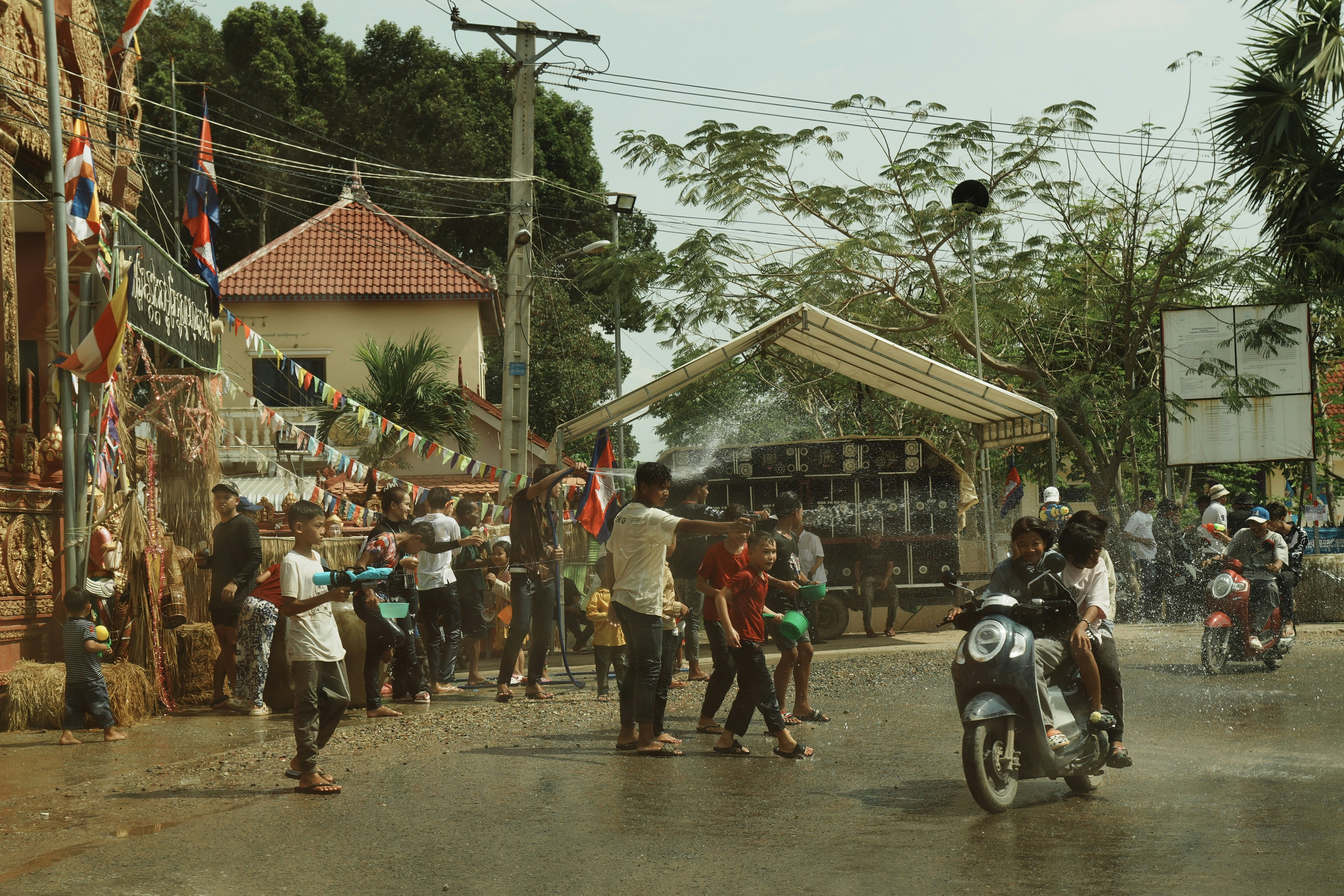 People celebrating with water guns on a sunny day.