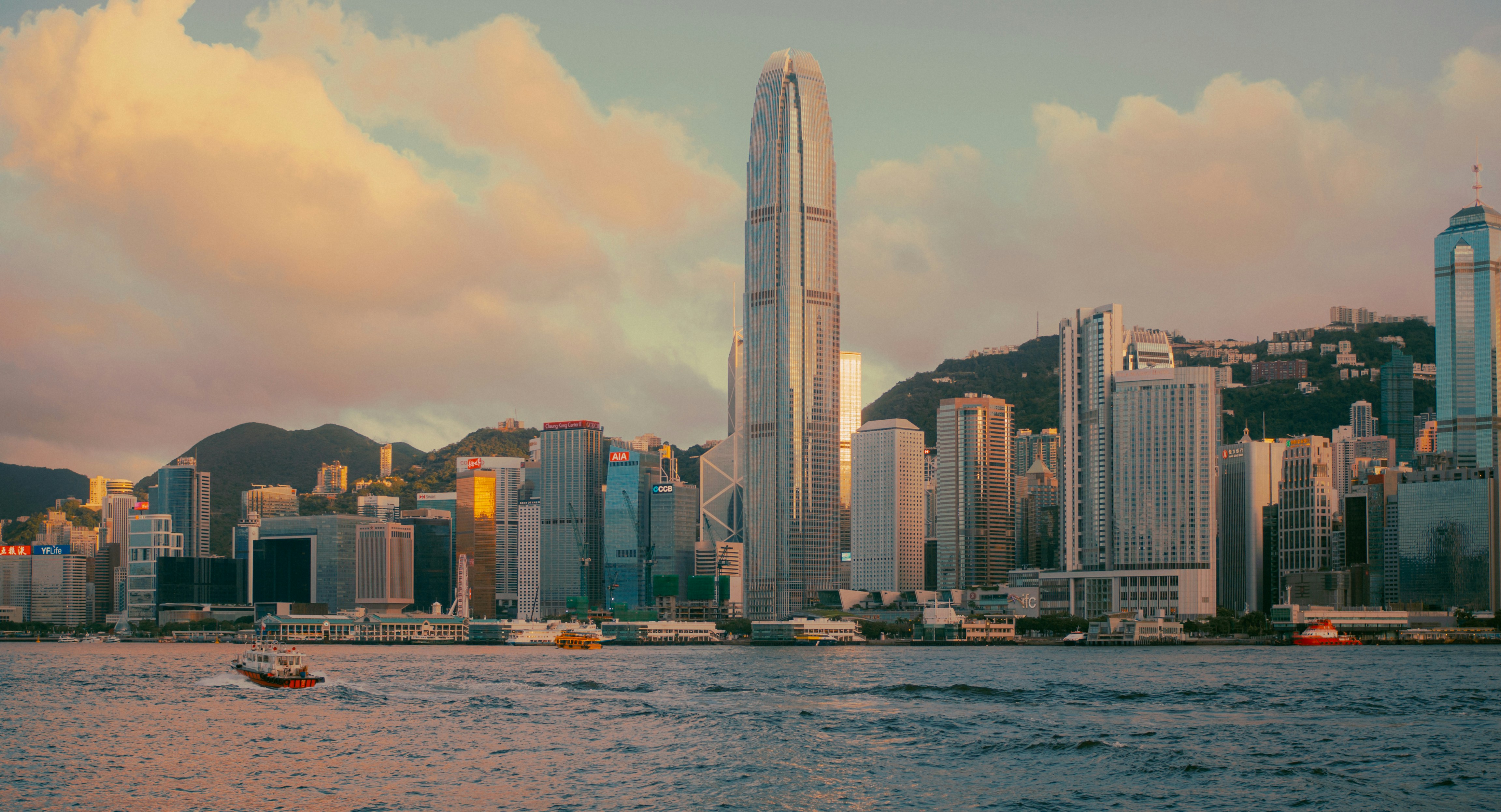 Modern cityscape with skyscrapers and a body of water.