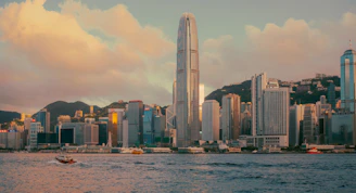 Modern cityscape with skyscrapers and a body of water.
