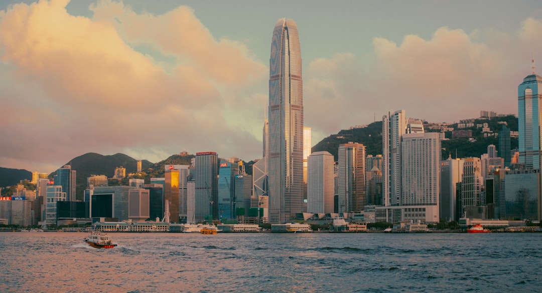 Modern cityscape with skyscrapers and a body of water.
