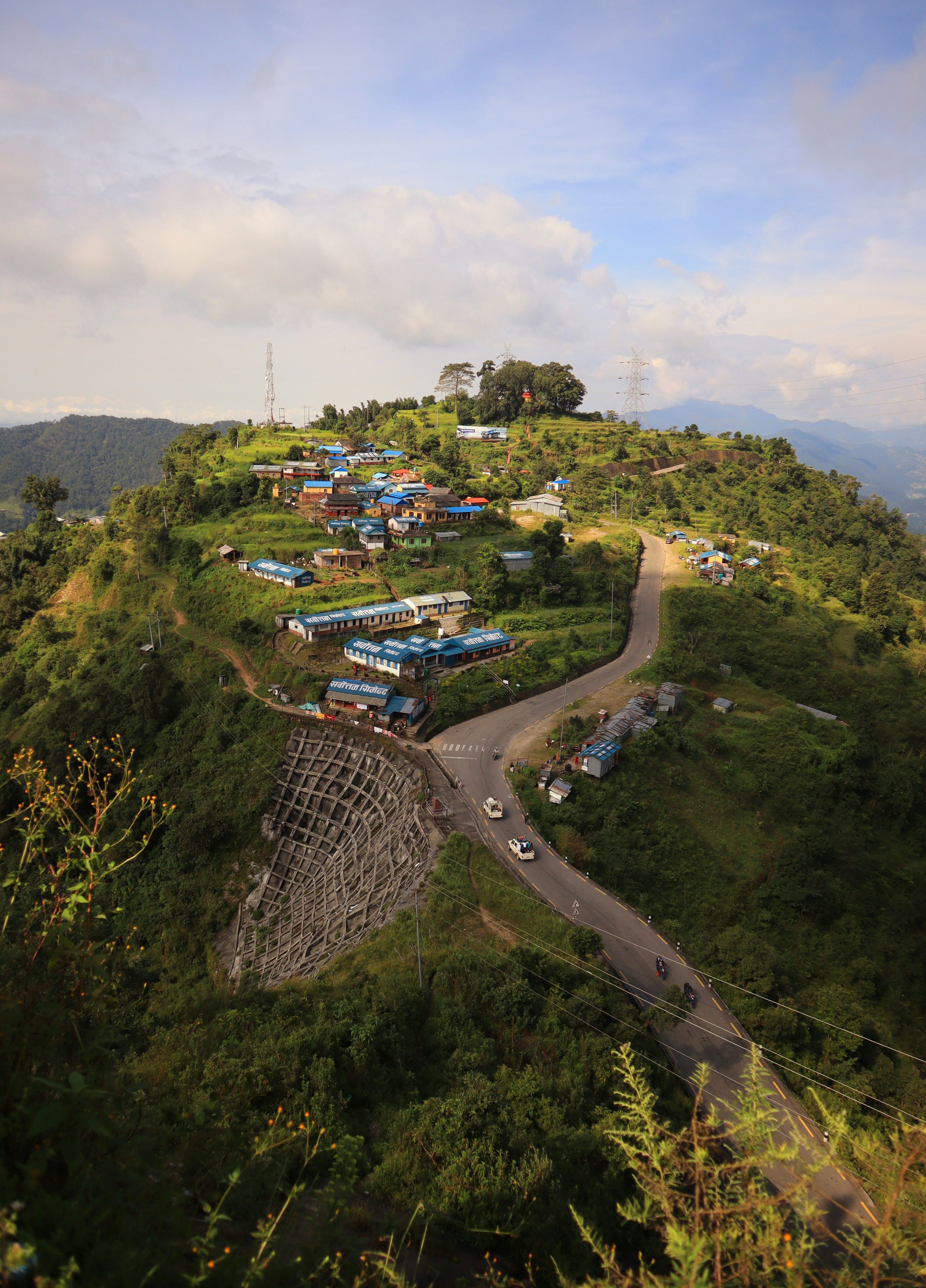 Desa terletak di lereng gunung hijau subur dengan jalan berkelok-kelok.